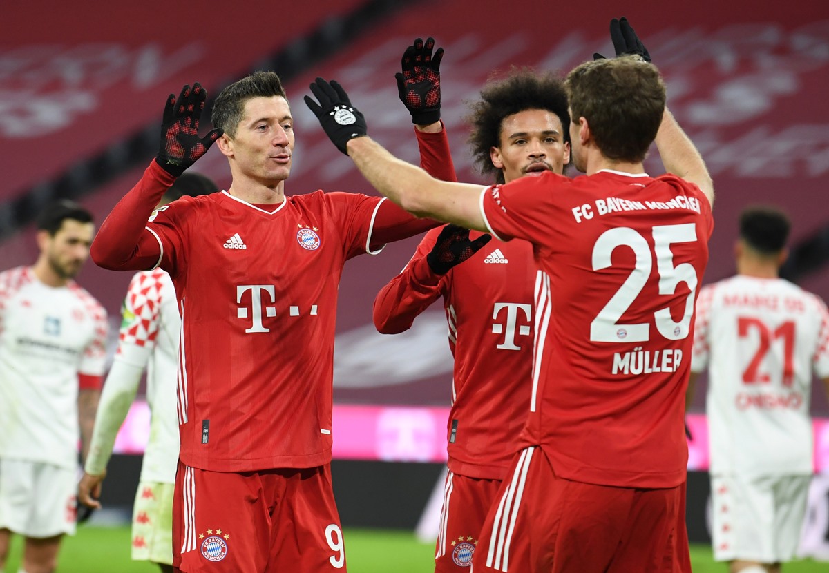 Soccer Football - Bundesliga - Bayern Munich v 1. FSV Mainz 05 - Allianz Arena, Munich, Germany - January 3, 2021 Bayern Munich's Robert Lewandowski celebrates scoring their fifth goal with Leroy Sane and Thomas Muller Pool via REUTERS