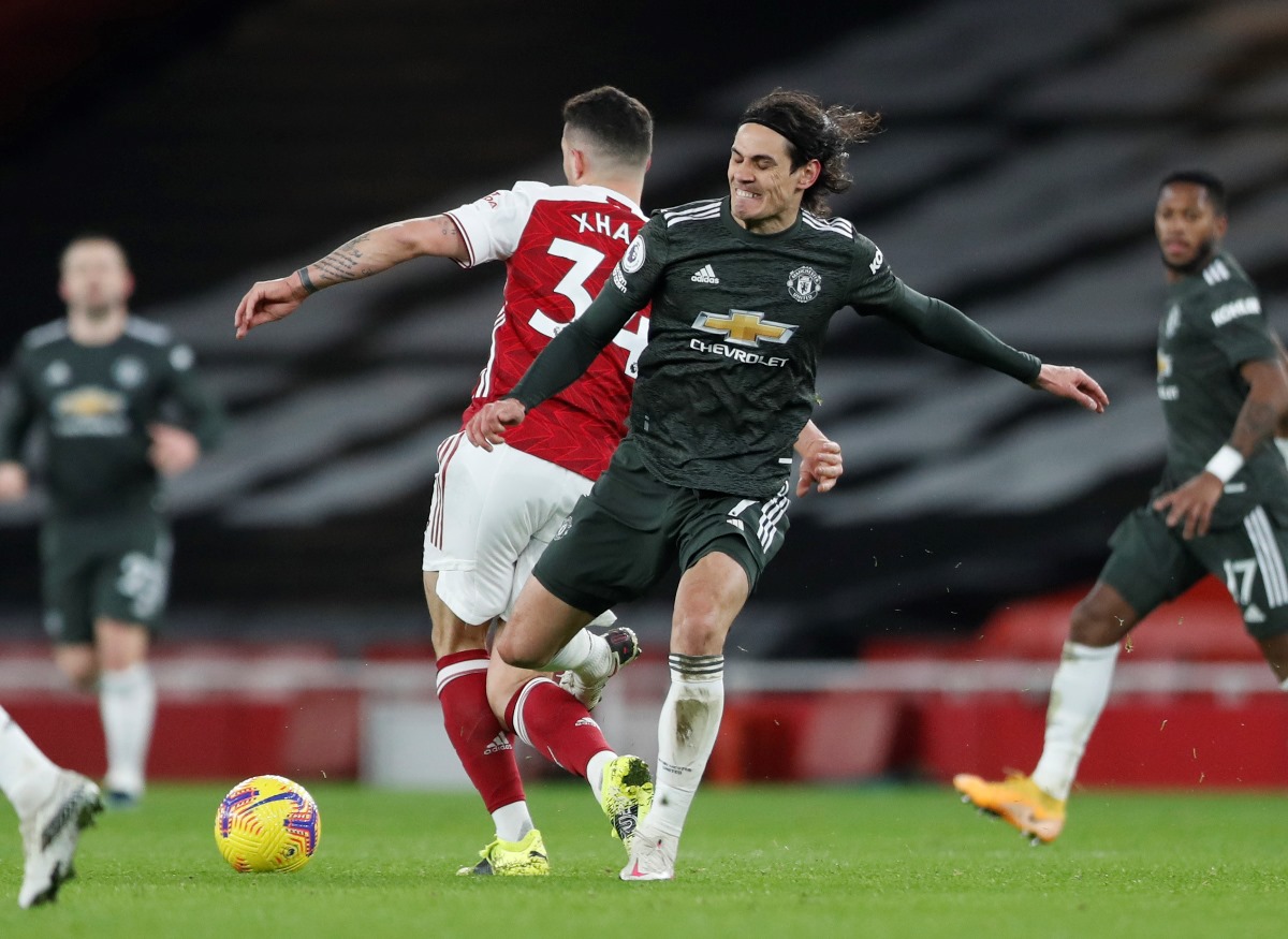 Soccer Football - Premier League - Arsenal v Manchester United - Emirates Stadium, London, Britain - January 30, 2021 Arsenal's Granit Xhaka in action with Manchester United's Edinson Cavani Pool via REUTERS