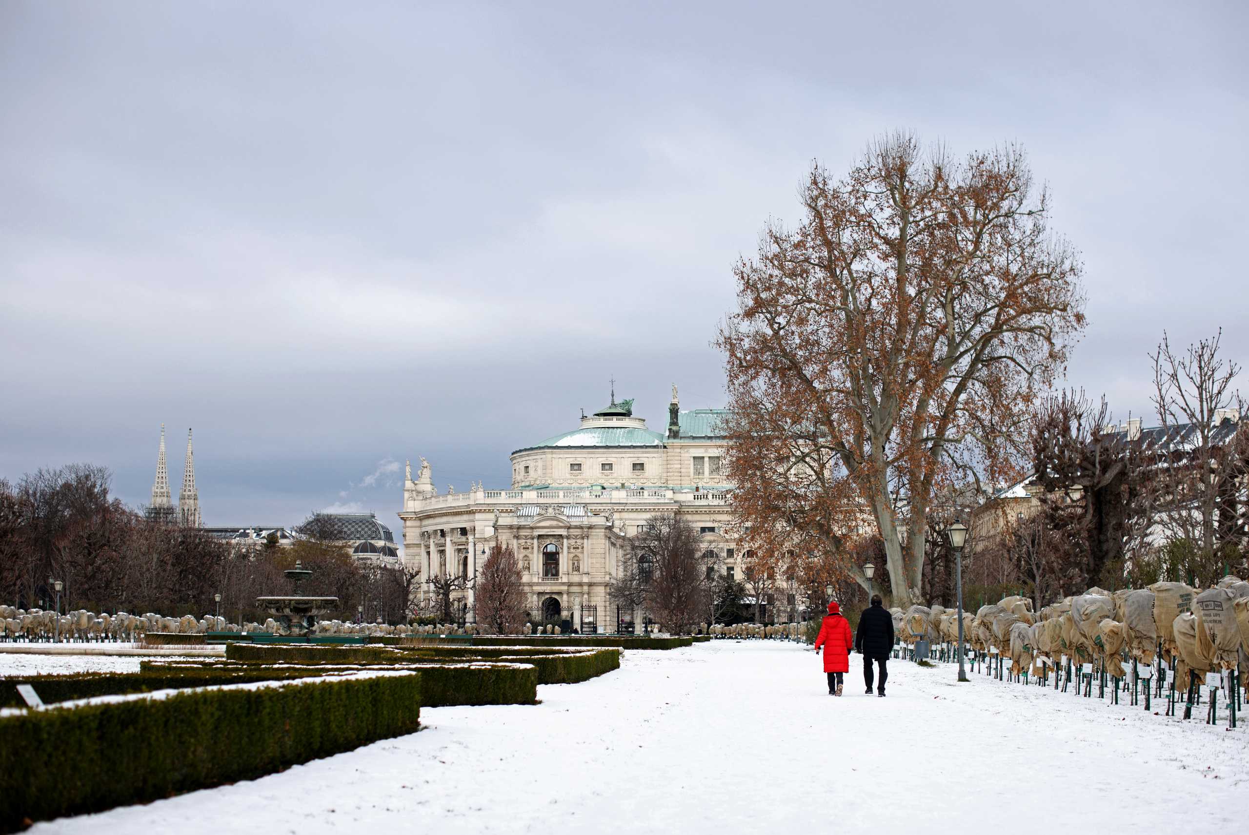 A couple strolls along a snow covered path in Volksgarten park as the coronavirus disease (COVID-19) outbreak continues in Vienna, Austria, January 17, 2021. REUTERS