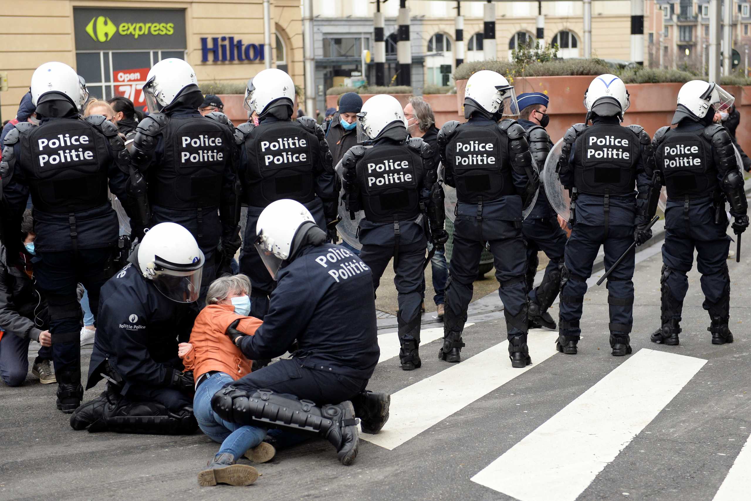 Police officers detain a person during a demonstration against restrictions put in place to curb the spread of the coronavirus disease (COVID-19) in Brussels, Belgium, January 31, 2021. REUTERS