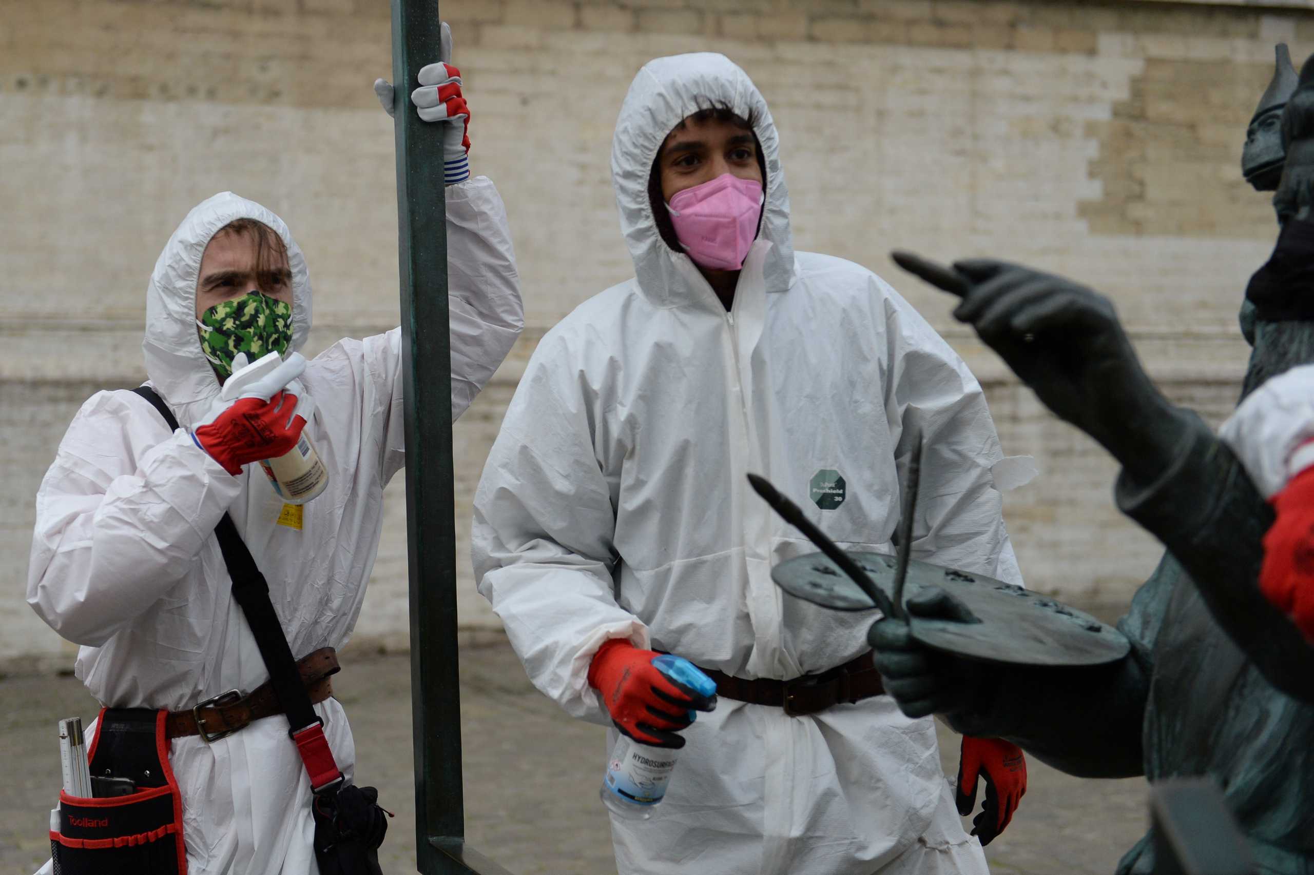 A pair of recently-jobless men, calling themselves the "COVID boys", patrols in central Brussels to give advice about social distancing and mask wearing, amid the outbreak of the coronavirus disease (COVID-19), Belgium January 20, 2021. Picture taken January 20, 2021. REUTERS