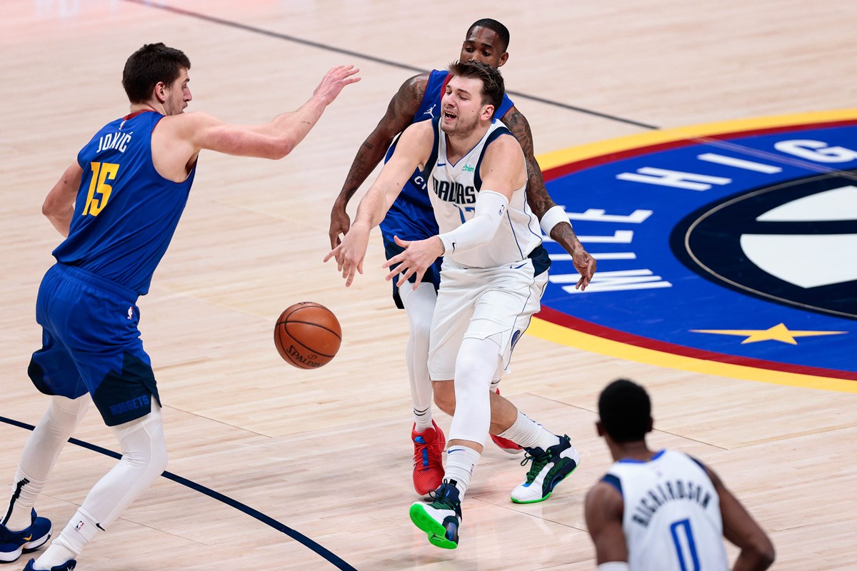 Jan 7, 2021; Denver, Colorado, USA; Dallas Mavericks guard Luka Doncic (77) passes the ball as Denver Nuggets center Nikola Jokic (15) and guard Will Barton III (5) guards in the first quarter at Ball Arena. Mandatory Credit: Isaiah J. Downing-USA TODAY Sports