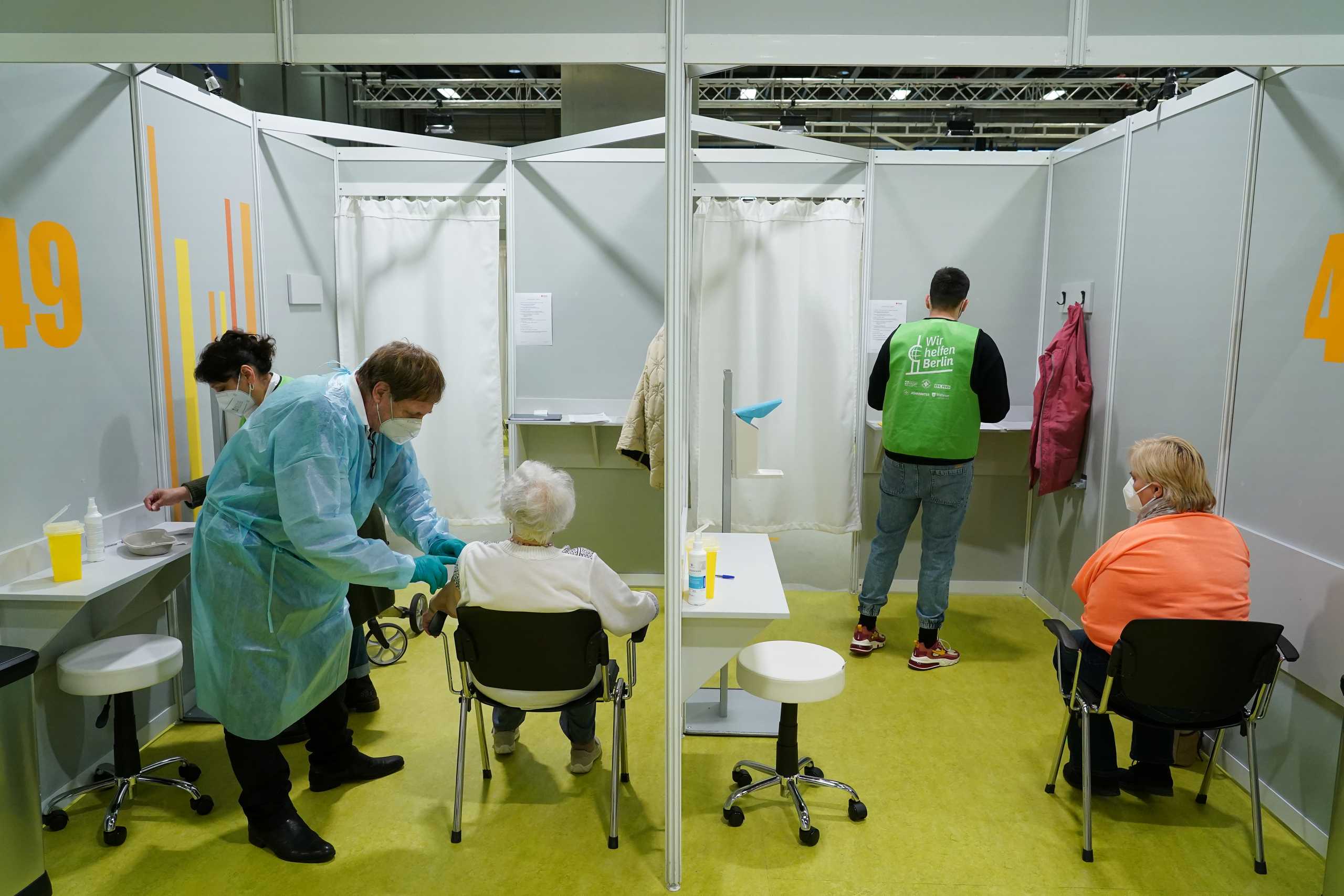 Elderly people are inoculated against the coronavirus disease (COVID-19) on the opening day of a vaccination center at the Messe Berlin trade fair grounds in Berlin, Germany January 18, 2021. Sean Gallup