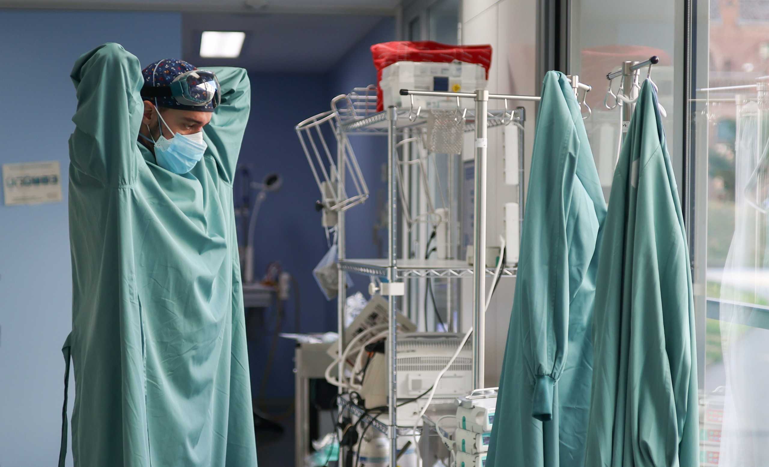 A hospital staff member prepares to treat a patient suffering from the coronavirus disease (COVID-19), in the Intensive Care Unit (ICU) at the Hospital de Sant Pau, after Catalonia's government imposed new restrictions in an effort to control a COVID-19 third wave, in Barcelona, Spain, January 21, 2021. REUTERS