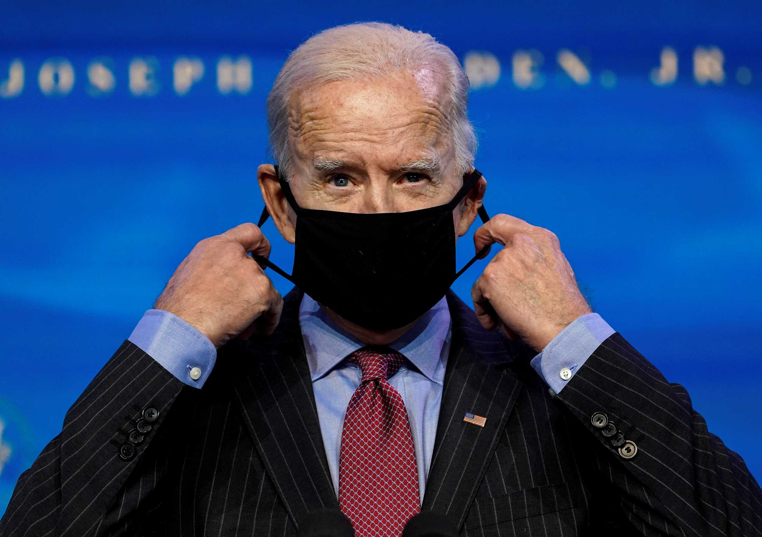 U.S. President-elect Joe Biden removes his mask as he announces members of economics and jobs team at his transition headquarters in Wilmington, Delaware, U.S., January 8, 2021. REUTERS