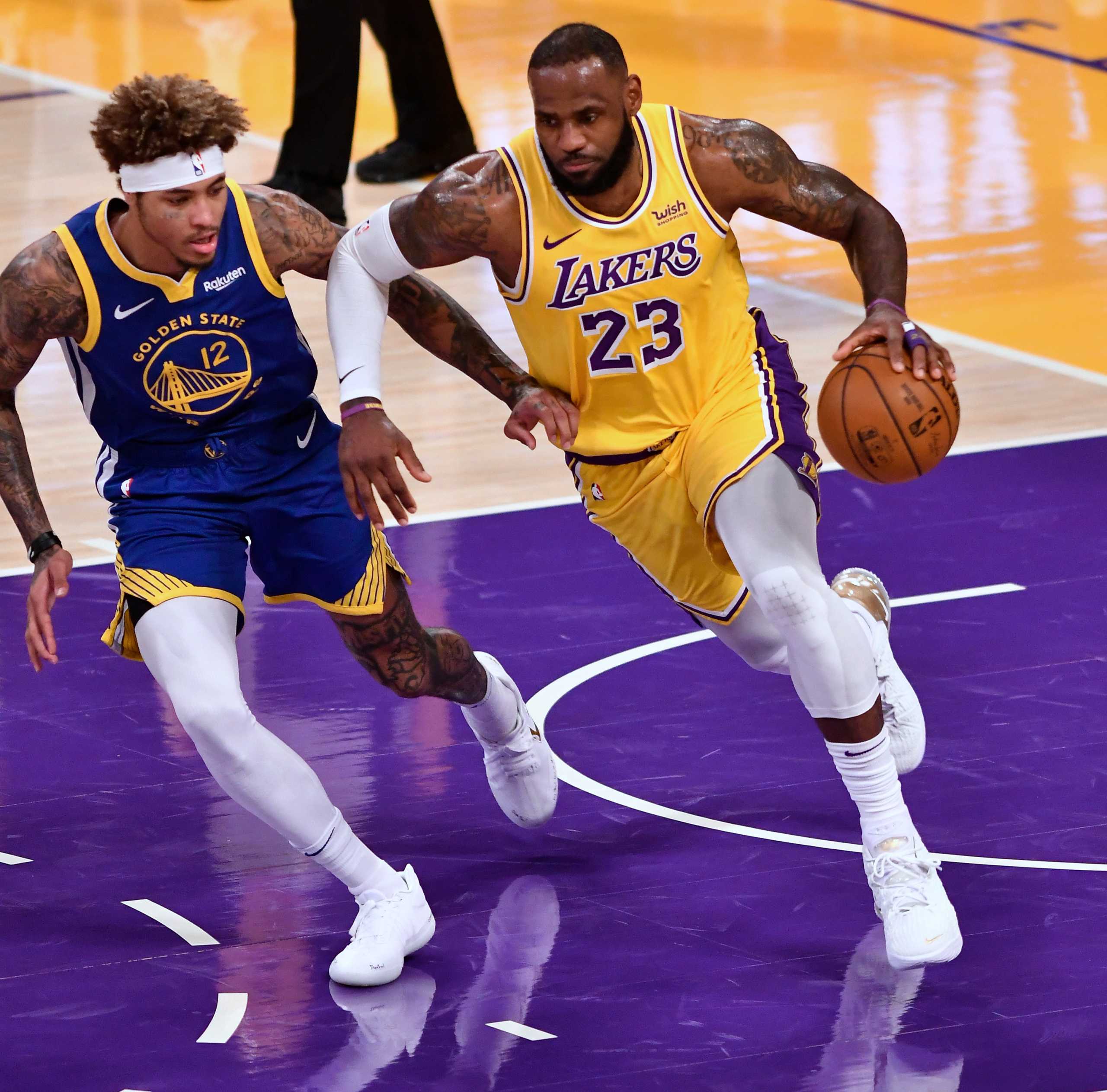 Jan 18, 2021; Los Angeles, California, USA; Los Angeles Lakers forward LeBron James (23) brings the ball up court as Golden State Warriors guard Kelly Oubre Jr. (12) defends during the second quarter at Staples Center. Mandatory Credit: Robert Hanashiro-USA TODAY Sports
