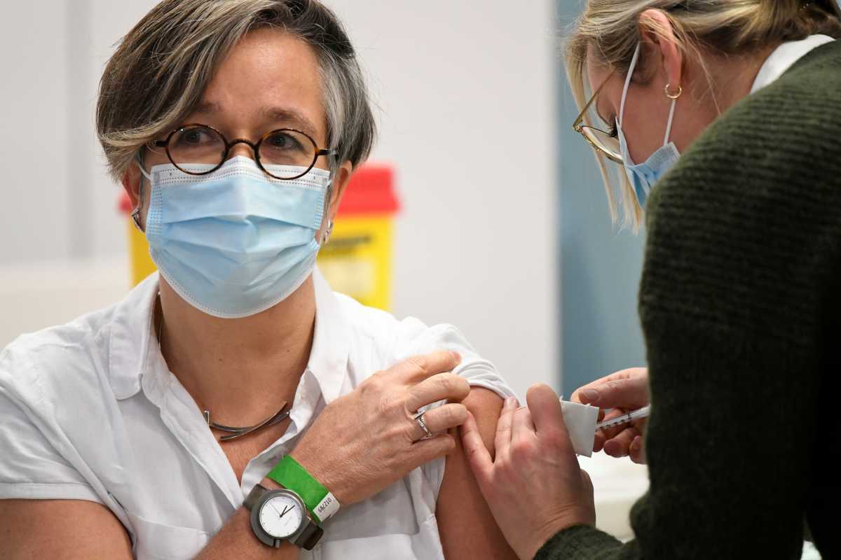 A healthcare worker receives the Pfizer