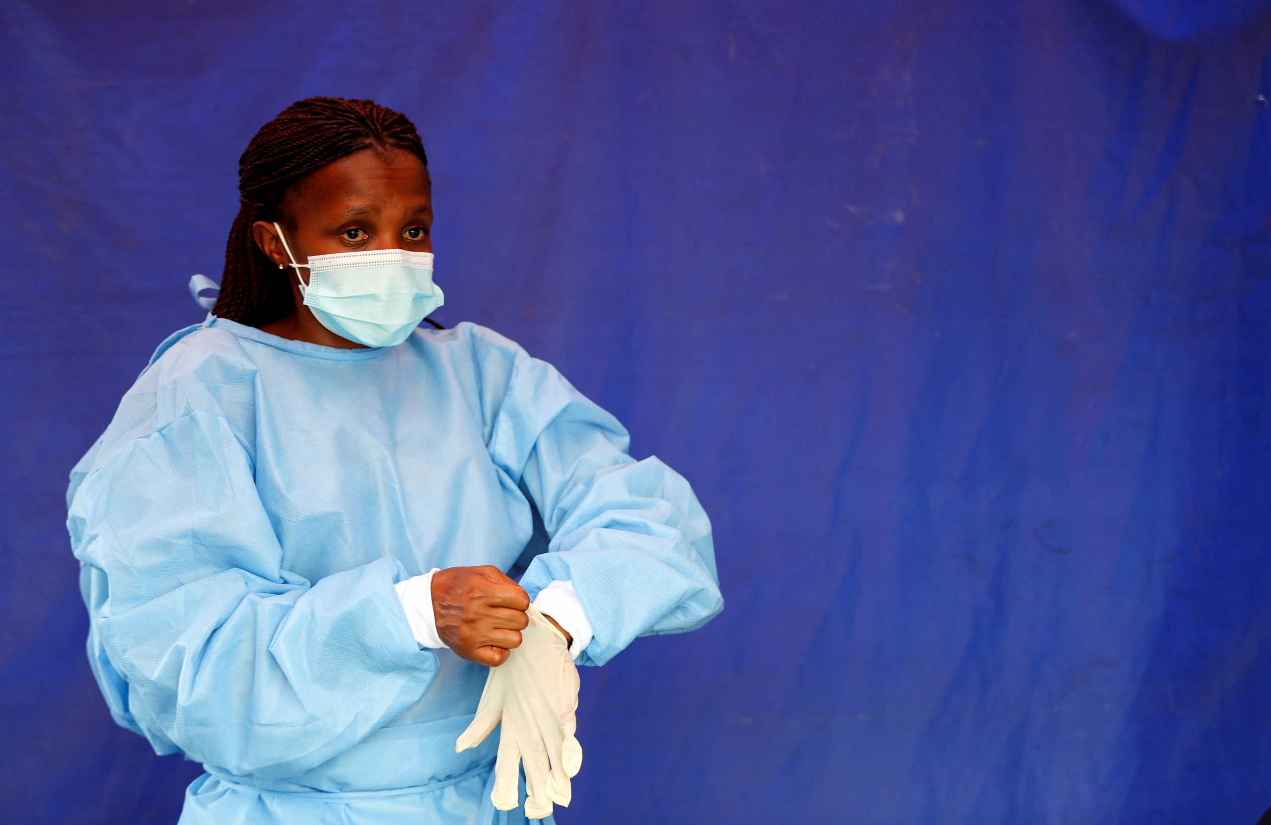 FILE PHOTO: A health worker wears protective clothing as she prepares for testing travellers for the coronavirus disease (COVID-19) amid a nationwide COVID-19 lockdown, at the Grasmere Toll Plaza, in Lenasia, South Africa, January 14, 2021. REUTERS