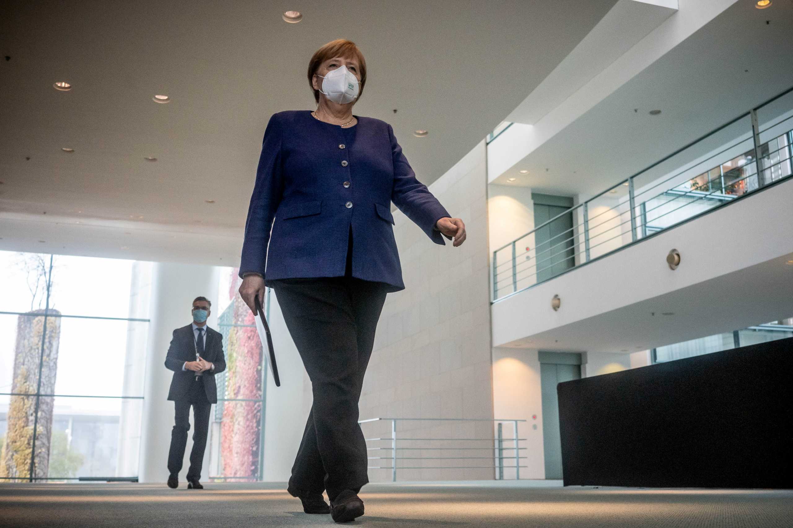 FILE PHOTO: German Chancellor Angela Merkel wears a protective mask as she arrives to give a statement on the outcome of the 2020 U.S. presidential election in Berlin, Germany, November 9, 2020.   Michael Kappeler