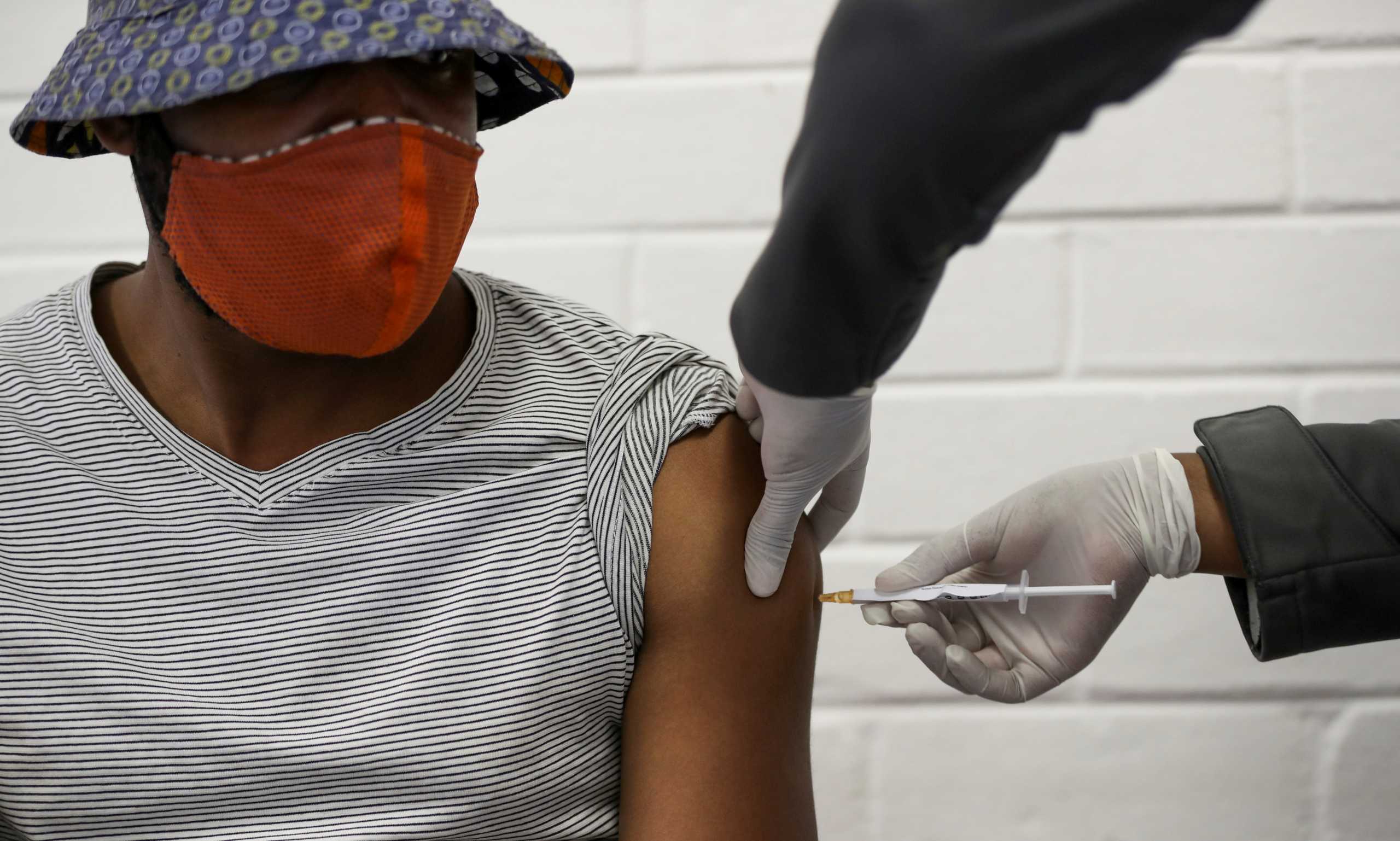 FILE PHOTO: A volunteer receives an injection from a medical worker during the country's first human clinical trial for a potential vaccine against the novel coronavirus, at Baragwanath Hospital in Soweto, South Africa, June 24, 2020. REUTERS