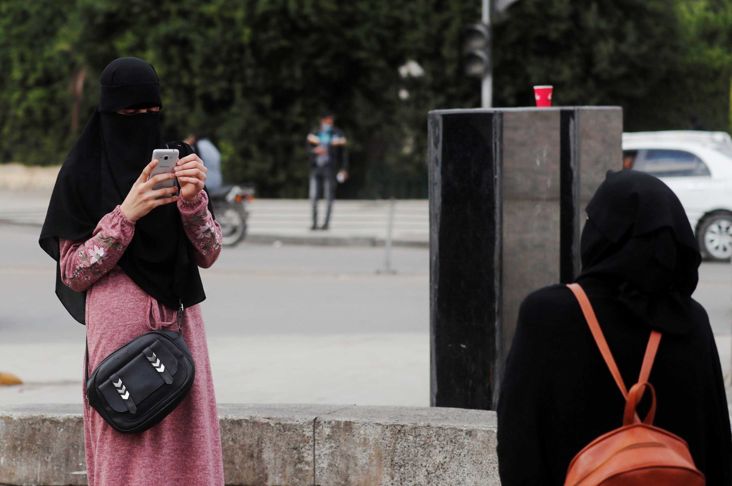 Egyptian women wearing a full veil (niqab) take pictures amid the coronavirus disease (COVID-19) pandemic on Qasr el-Nil bridge, leading to Cairo's Tahrir Square, in Cairo, Egypt December 17, 2020. Picture taken December 17, 2020. REUTERS