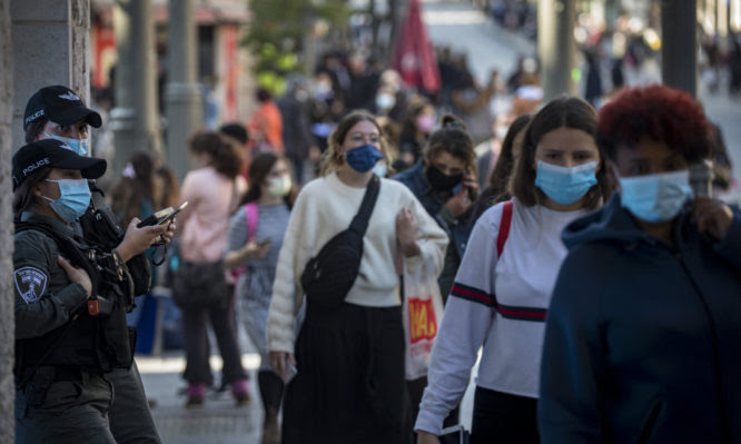 Jerusalemites wearing a face mask walk in Jerusalem City Center on November 29, 2020, as Israel steps out of coronavirus lockdown and rolls back restrictions. Photo by Olivier Fitoussi