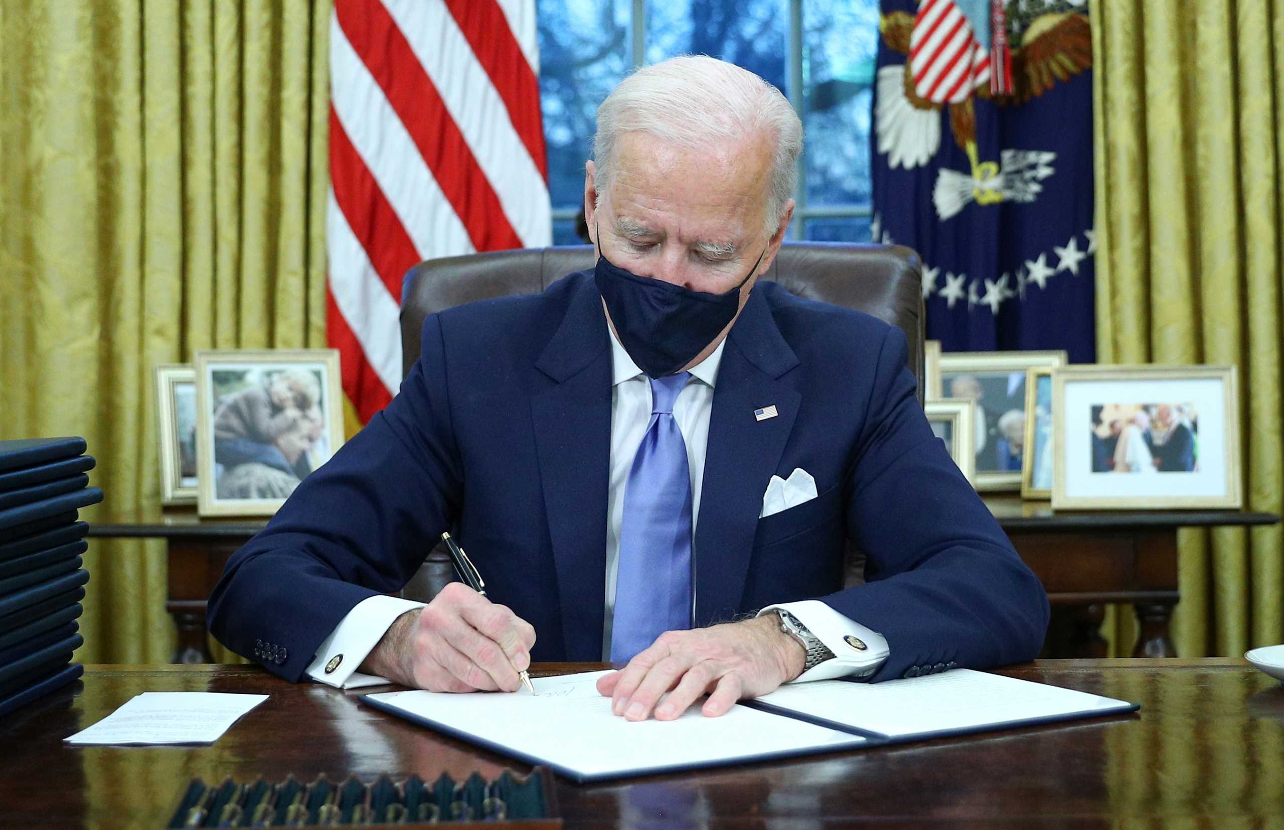 U.S. President Joe Biden signs executive orders in the Oval Office of the White House in Washington, after his inauguration as the 46th President of the United States, U.S., January 20, 2021. REUTERS