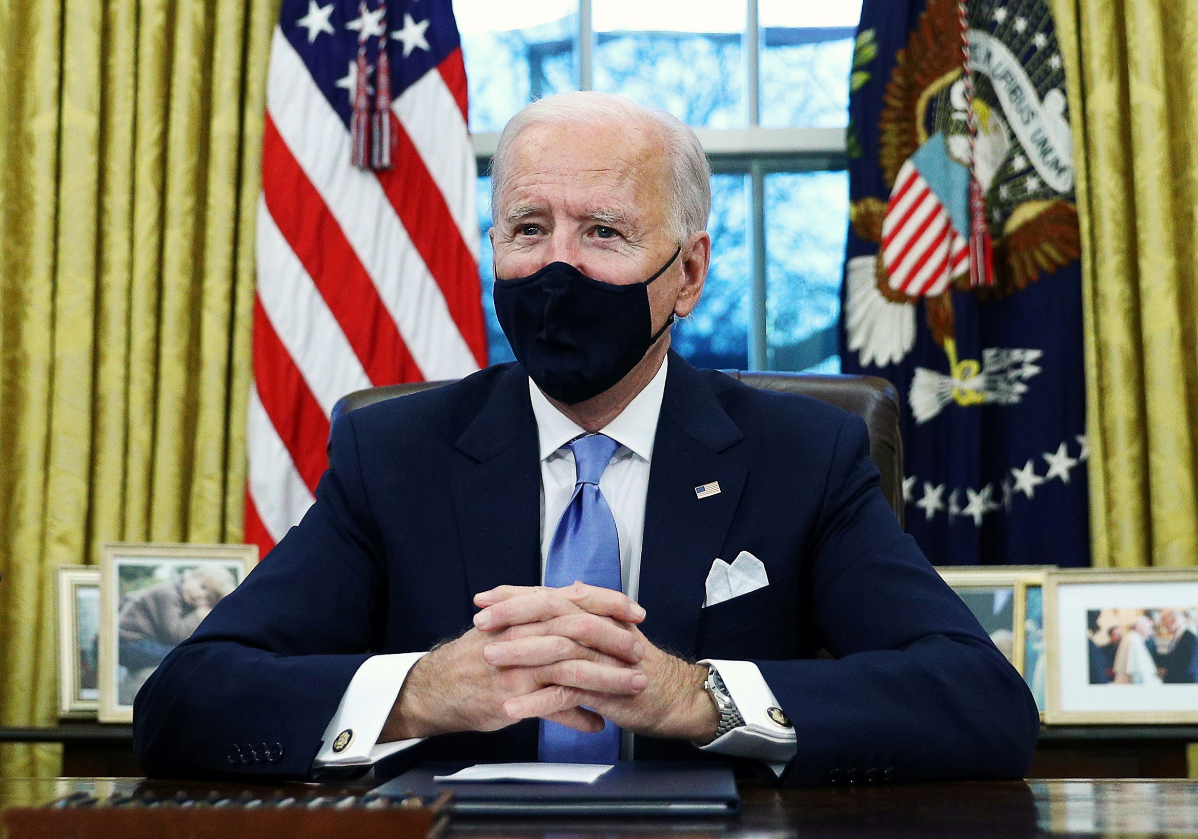 U.S. President Joe Biden signs executive orders in the Oval Office of the White House in Washington, after his inauguration as the 46th President of the United States, U.S., January 20, 2021. REUTERS