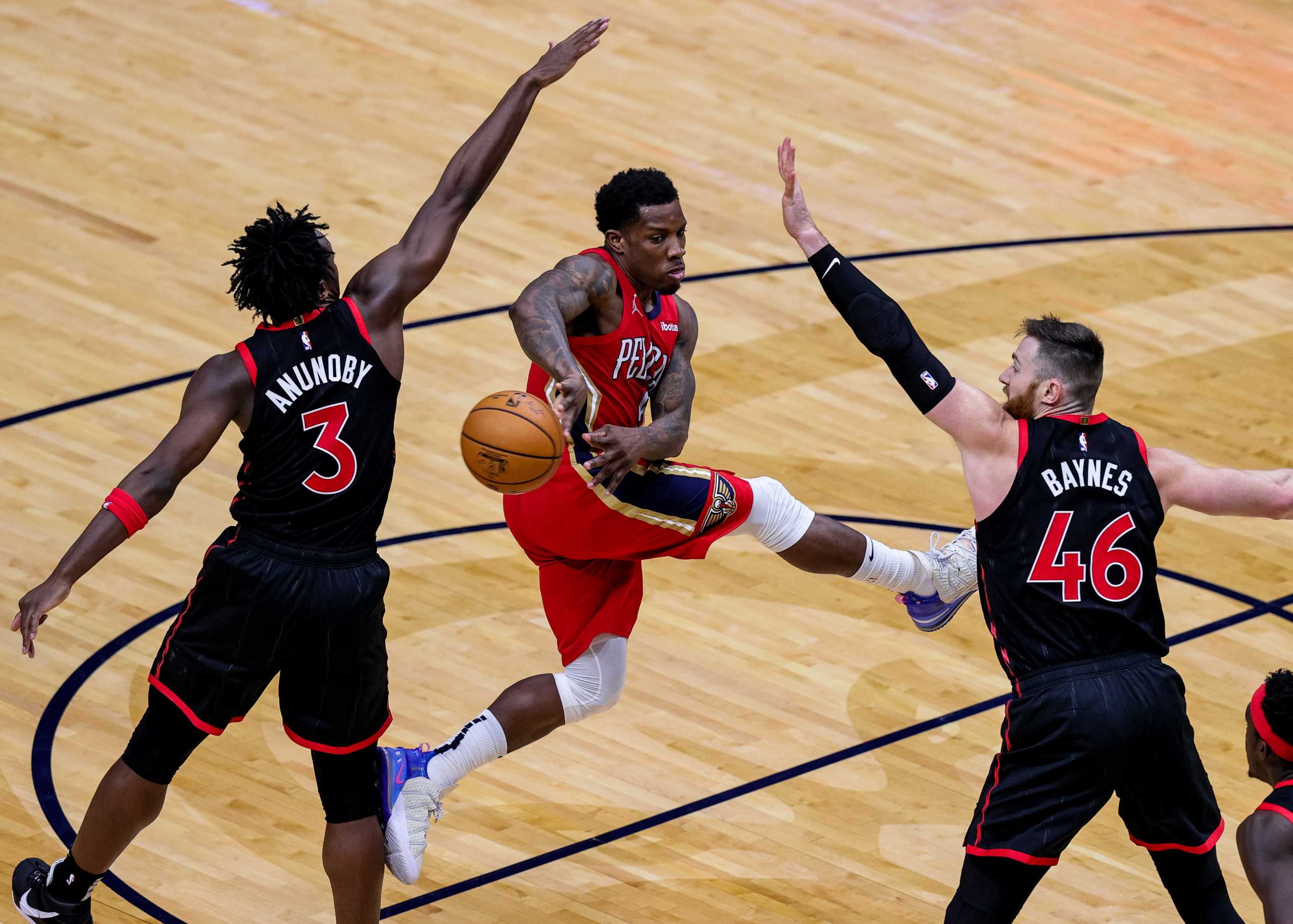 Jan 2, 2021; New Orleans, Louisiana, USA;  New Orleans Pelicans guard Eric Bledsoe (middle) passes the ball around Toronto Raptors forward OG Anunoby (3) during the third quarter  at the Smoothie King Center. Mandatory Credit: Stephen Lew-USA TODAY Sports