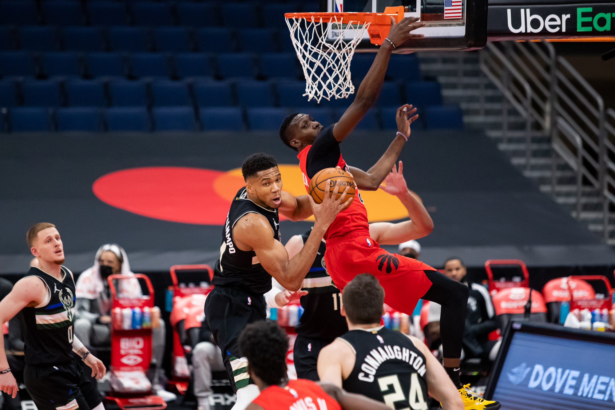Jan 27, 2021; Tampa, Florida, USA; Milwaukee Bucks forward Giannis Antetokounmpo (34) grabs a rebound from under Toronto Raptors forward Chris Boucher (25) during the second quarter of a game at Amalie Arena. Mandatory Credit: Mary Holt-USA TODAY Sports