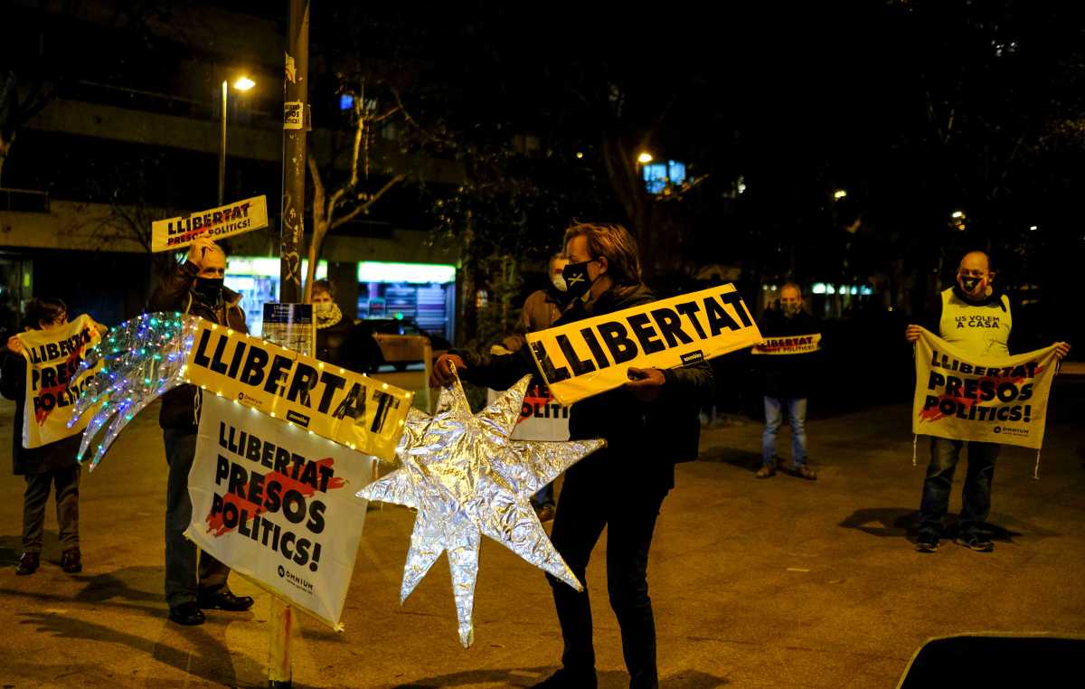 Catalan independence supporters hold signs reading "Freedom" and "Freedom for Political Prisoners", the day before a meeting of parliamentary groups to postpone the Catalan elections, in Barcelona, Spain January 14, 2021. Picture taken January 14, 2021. REUTERS