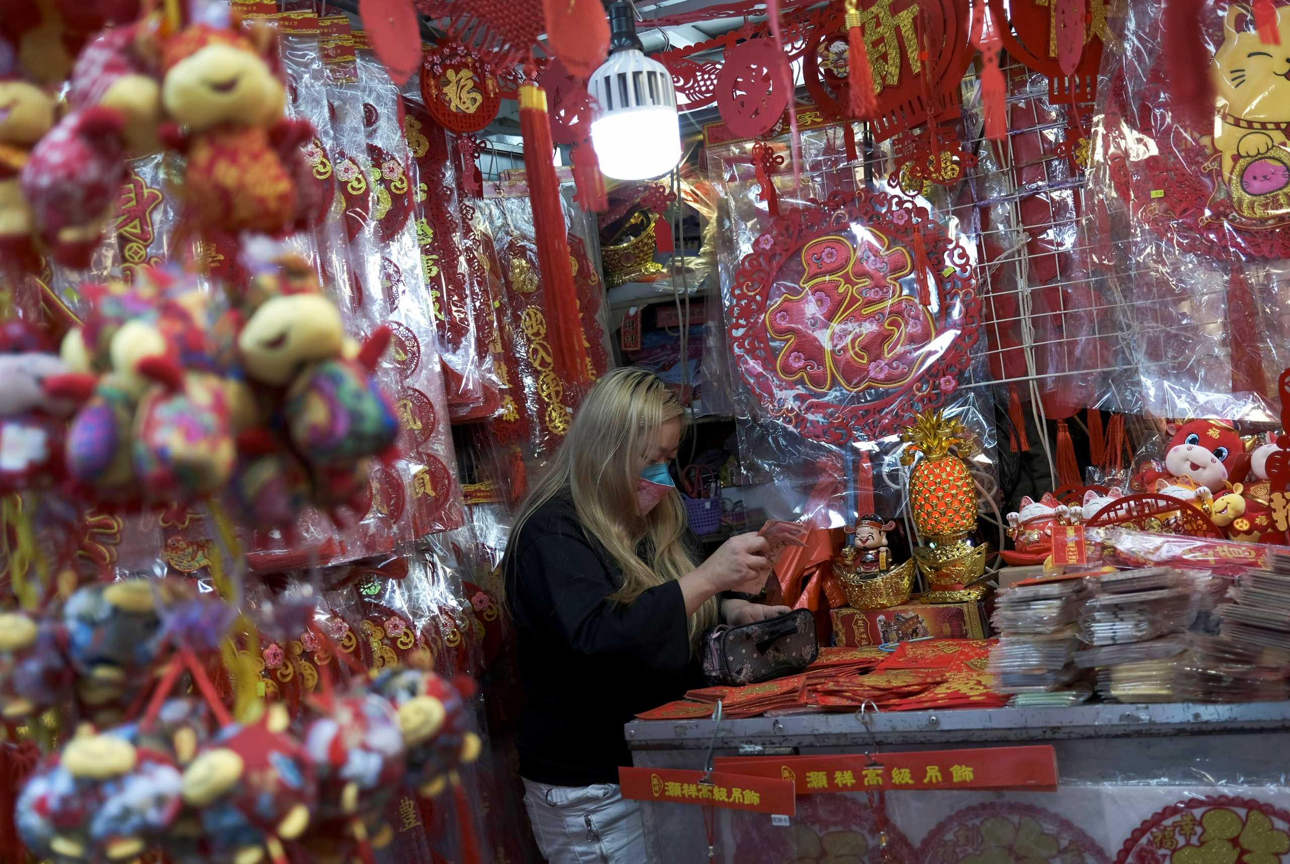 A vendor wearing a face mask is seen at her street stall with decorations, ahead of the Chinese Lunar New Year, following the coronavirus disease (COVID-19) outbreak, in Hong Kong, China January 28, 2021. REUTERS