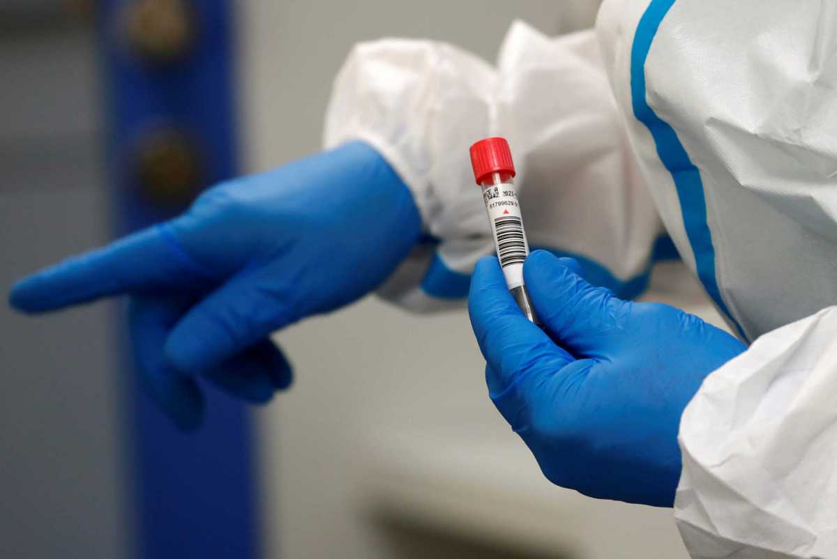 A German Red Cross medical staff holds a traveller's coronavirus disease (COVID-19) smear-test stick, who returned from the Ukraine, and was voluntary taken at the new Corona test station of the central bus location in Berlin, Germany, August 5, 2020. REUTERS