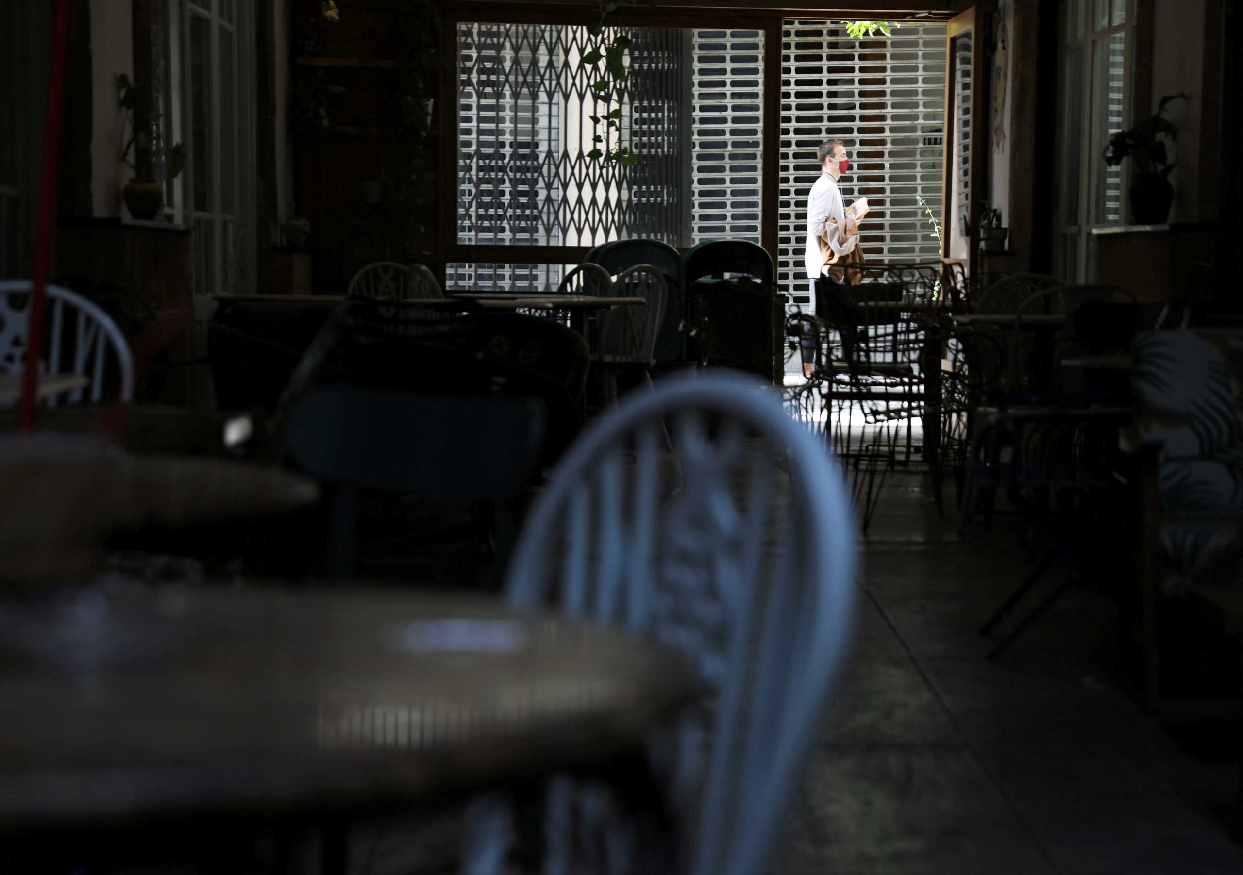 FILE PHOTO: A man wearing a protective mask walks outside a closed cafe, amid the coronavirus disease (COVID-19) pandemic in Nicosia, Cyprus January 8, 2021. REUTERS