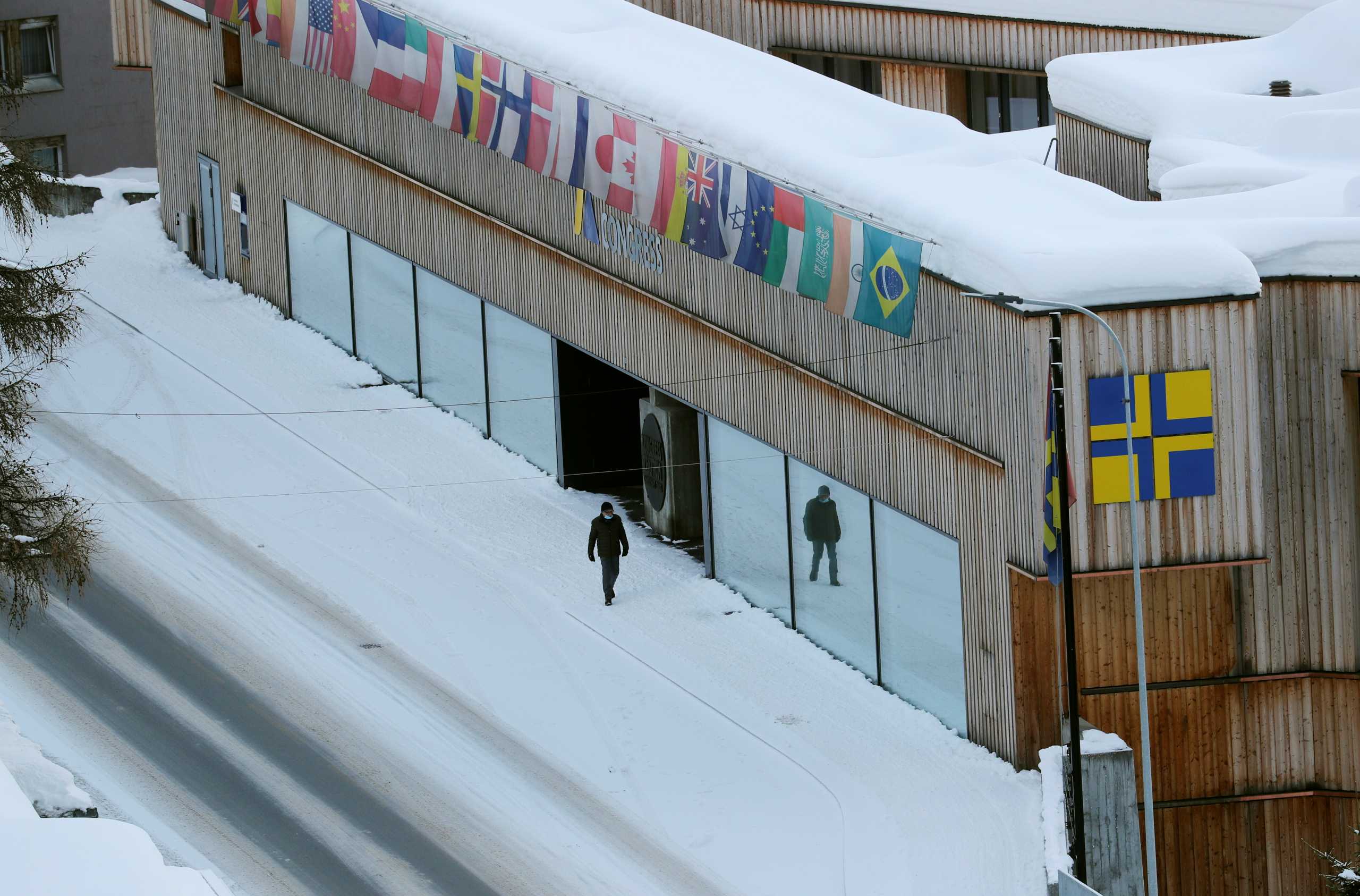 A man walks past the congress center along the Promenade street as the coronavirus disease (COVID-19) continues in Davos, Switzerland January 22, 2021. Picture taken January 22, 2021.  REUTERS