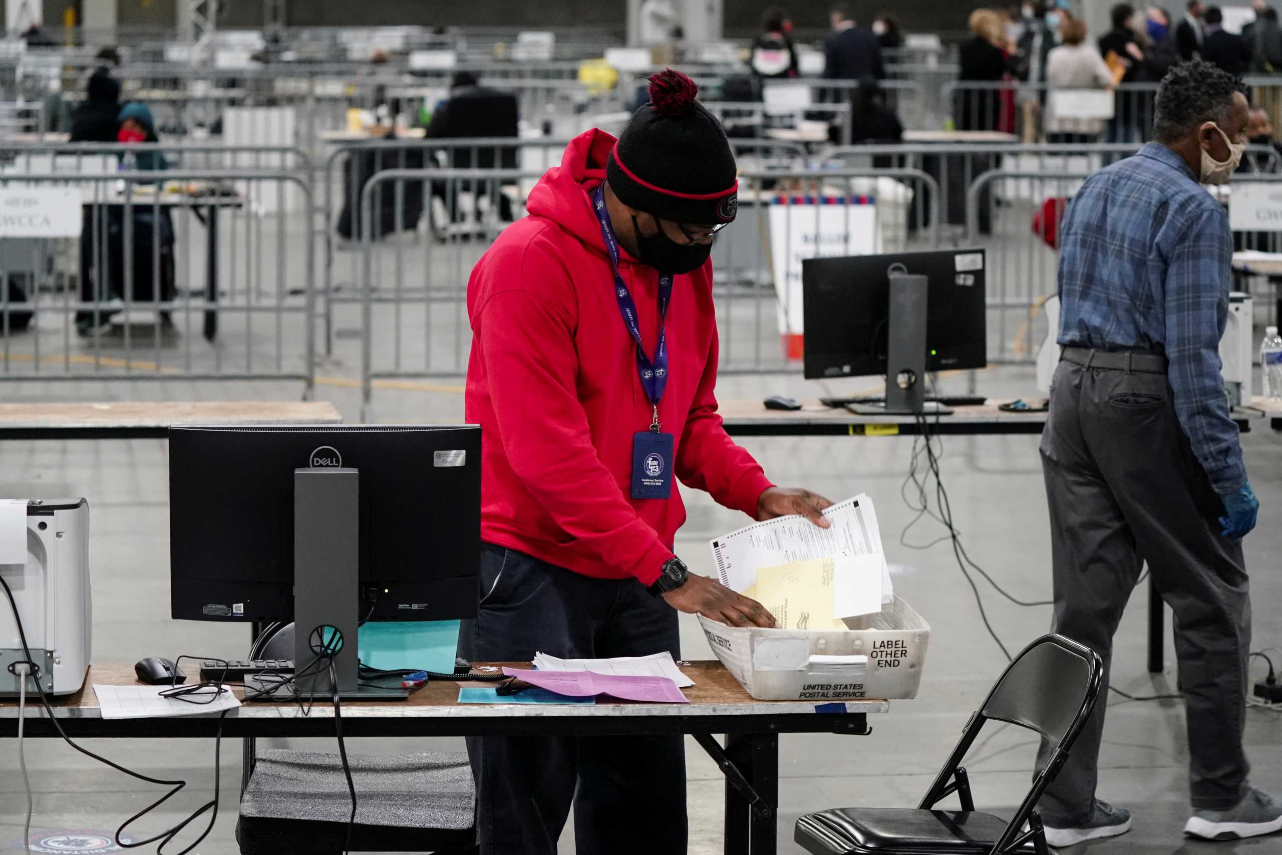 A Fulton County election worker takes absentee ballots out of a container to scan at the Georgia World Congress Center in Atlanta, Georgia, U.S., January 5, 2021.  REUTERS