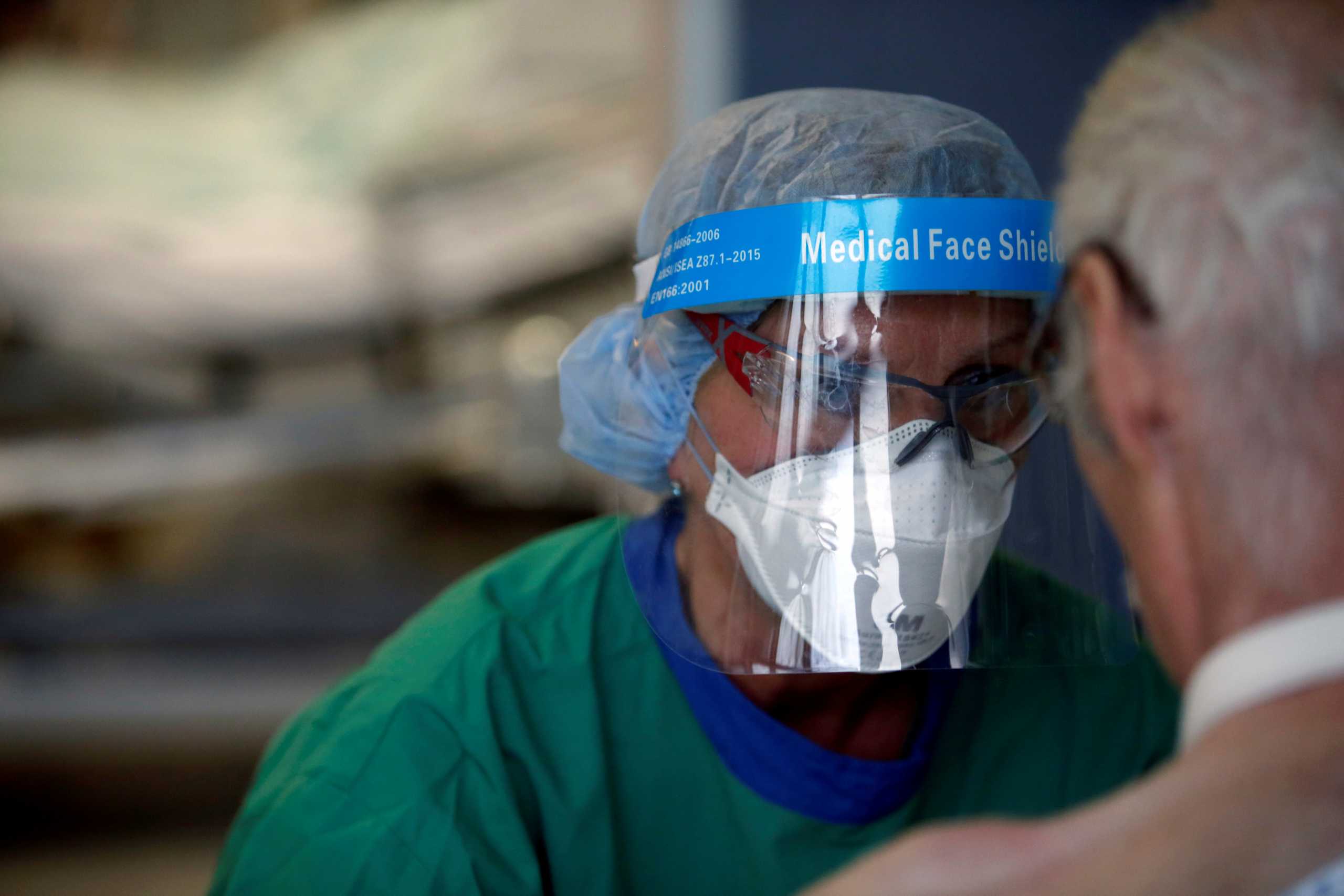 FILE PHOTO: A medical worker in a protective suit attends to coronavirus disease (COVID-19) patient at the intensive care unit (ICU) at the university hospital in Aachen, Germany, December 21, 2020. REUTERS