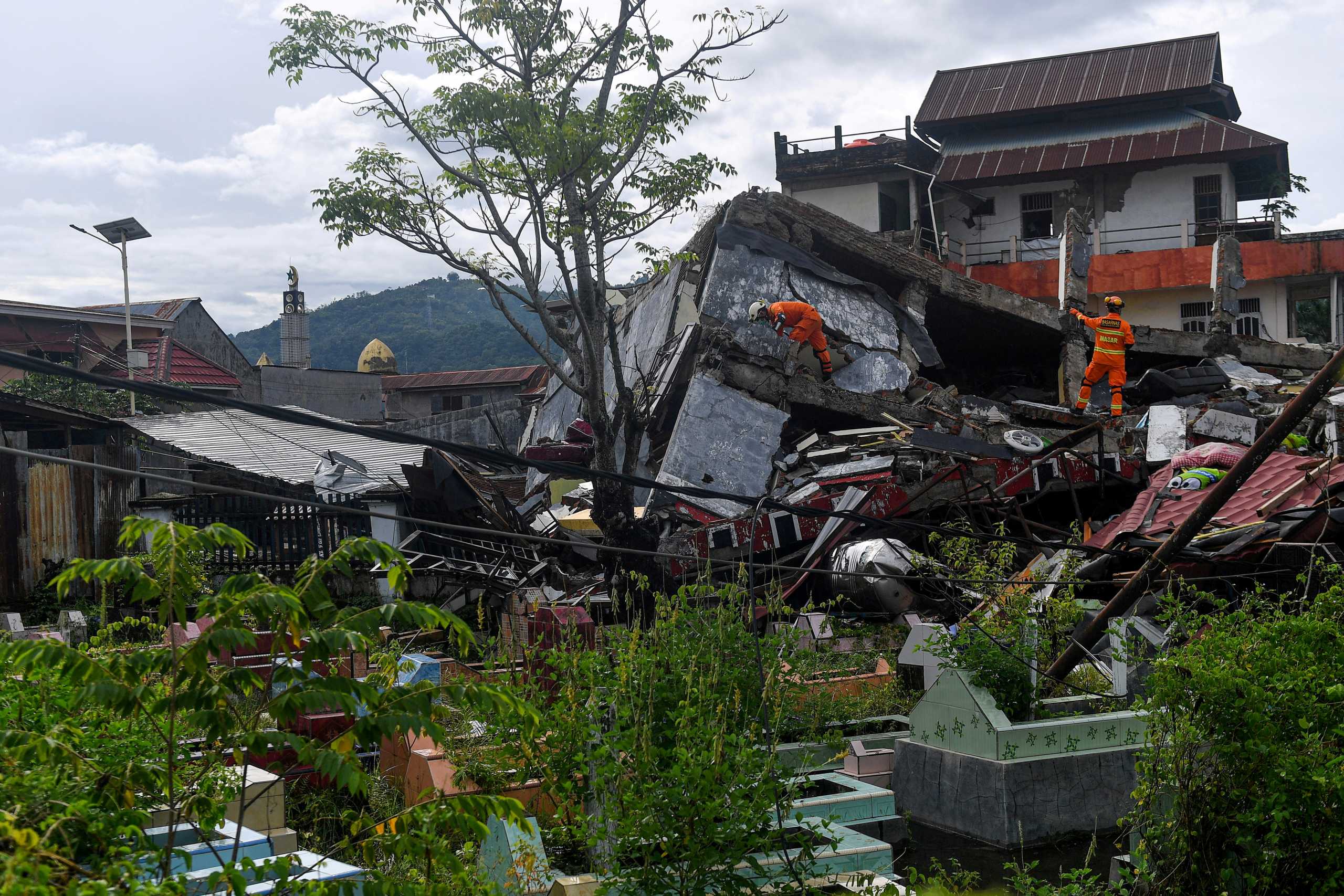 Search and rescue personnel inspect a collapsed building following an earthquake in Mamuju, West Sulawesi province, Indonesia, January 16, 2021. Sigid Kurniawan