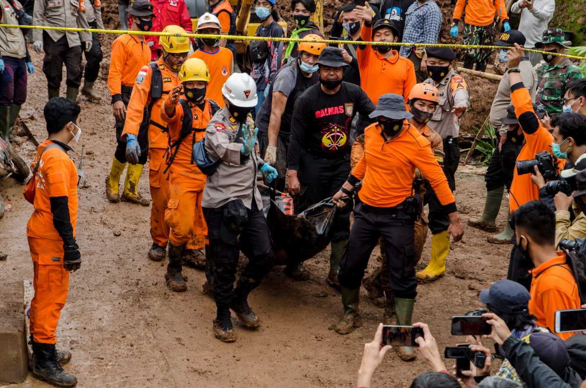 Indonesian rescuers carry a body bag during the search for victims buried by landslides in Sumedang, West Java Province, Indonesia, January 10, 2021 in this photo taken by Antara Foto
