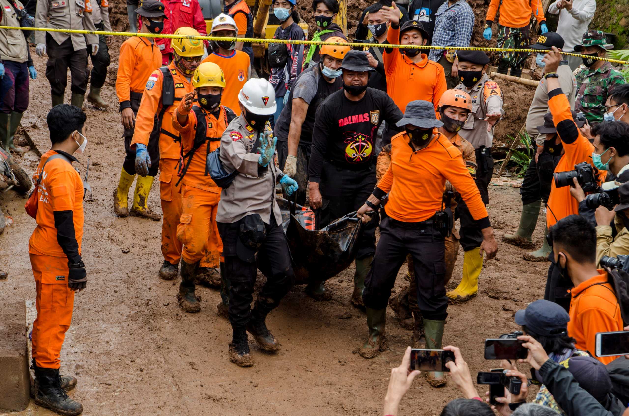 Indonesian rescuers carry a body bag during the search for victims buried by landslides in Sumedang, West Java Province, Indonesia, January 10, 2021 in this photo taken by Antara Foto