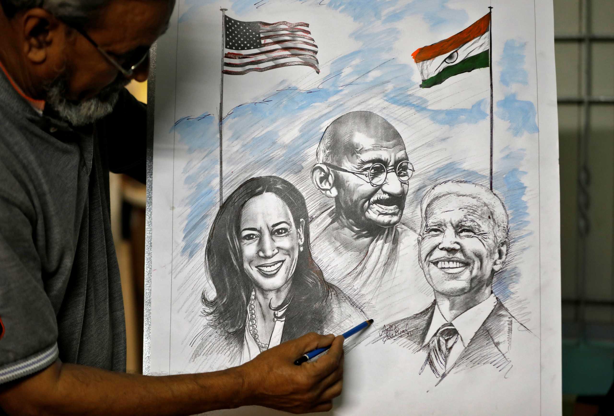 Aejaz Saiyad, an artist, gives finishing touches to a drawing of U.S. President-elect Joe Biden, Vice President-elect Kamala Harris and India's independence hero Mahatma Gandhi at his home in Ahmedabad, India, January 20, 2021. REUTERS