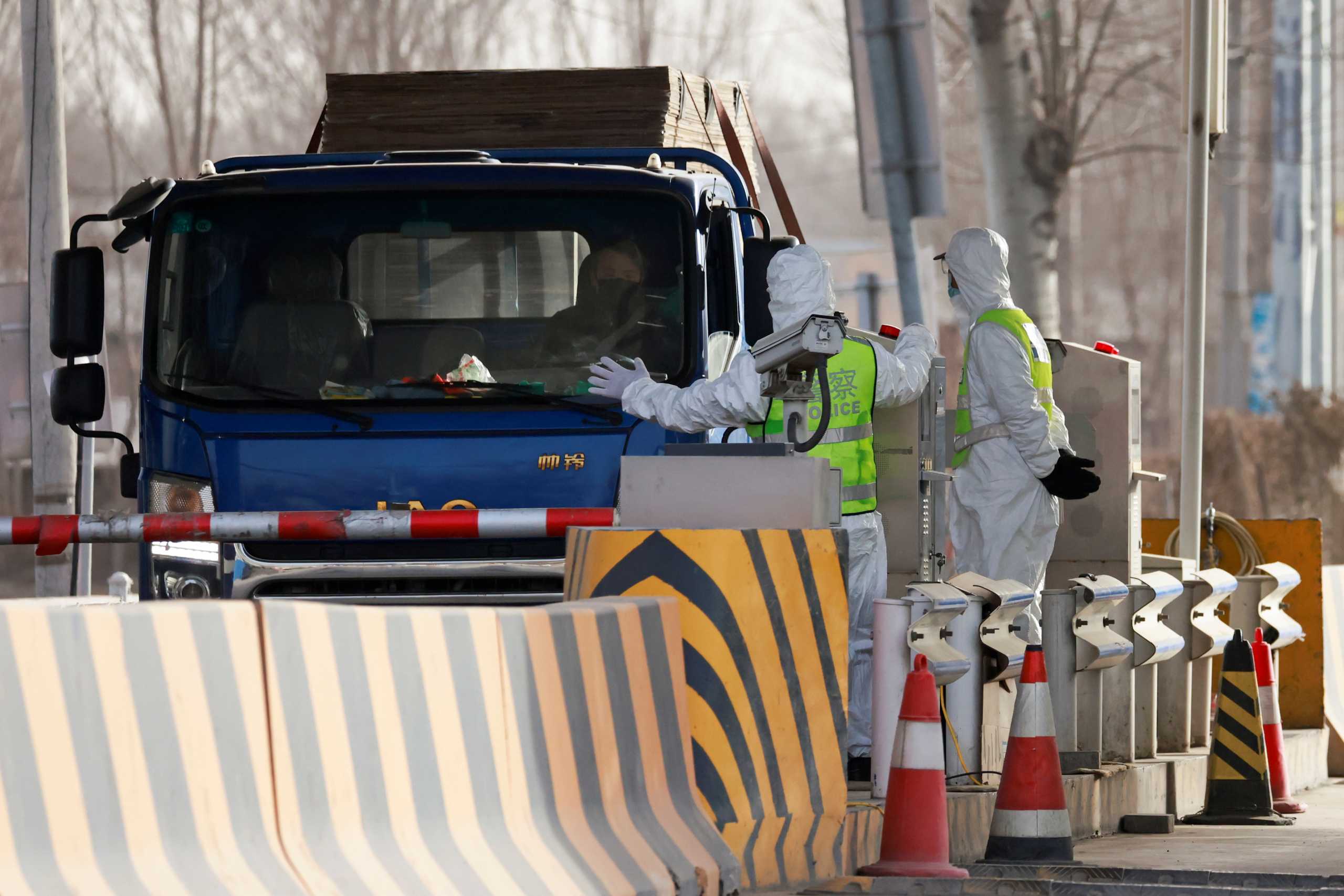 Police officers in PPE stop a car coming from Hebei province at a checkpoint, following the coronavirus disease (COVID-19) outbreak, on the outskirts of Beijing, China January 12, 2021. REUTERS