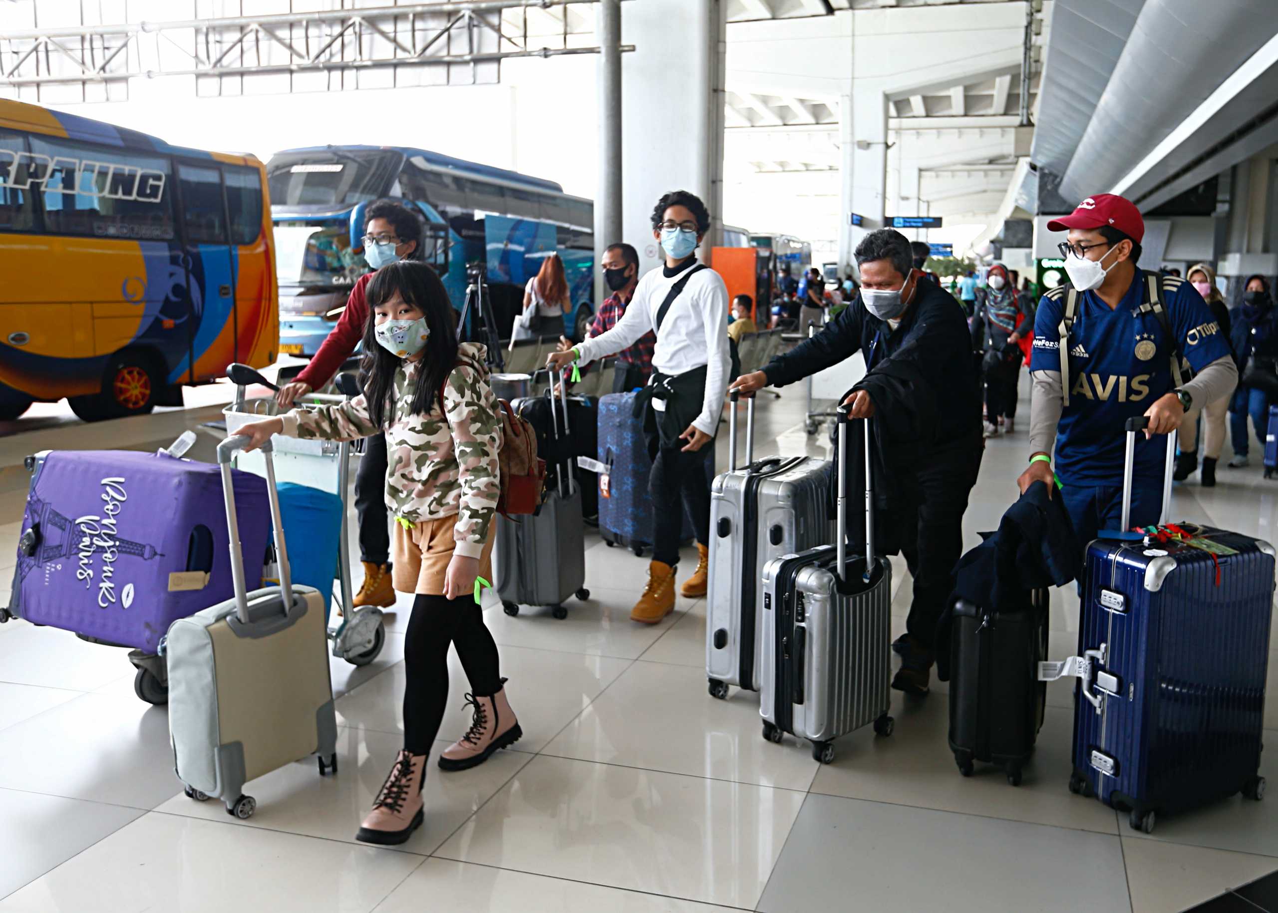 People walk with their luggage at the Soekarno-Hatta Airport following Indonesia's government decision to ban foreign tourists from entry to prevent the spread of coronavirus disease (COVID-19), in Tangerang, on the outskirts of Jakarta, Indonesia, January 1, 2021. REUTERS