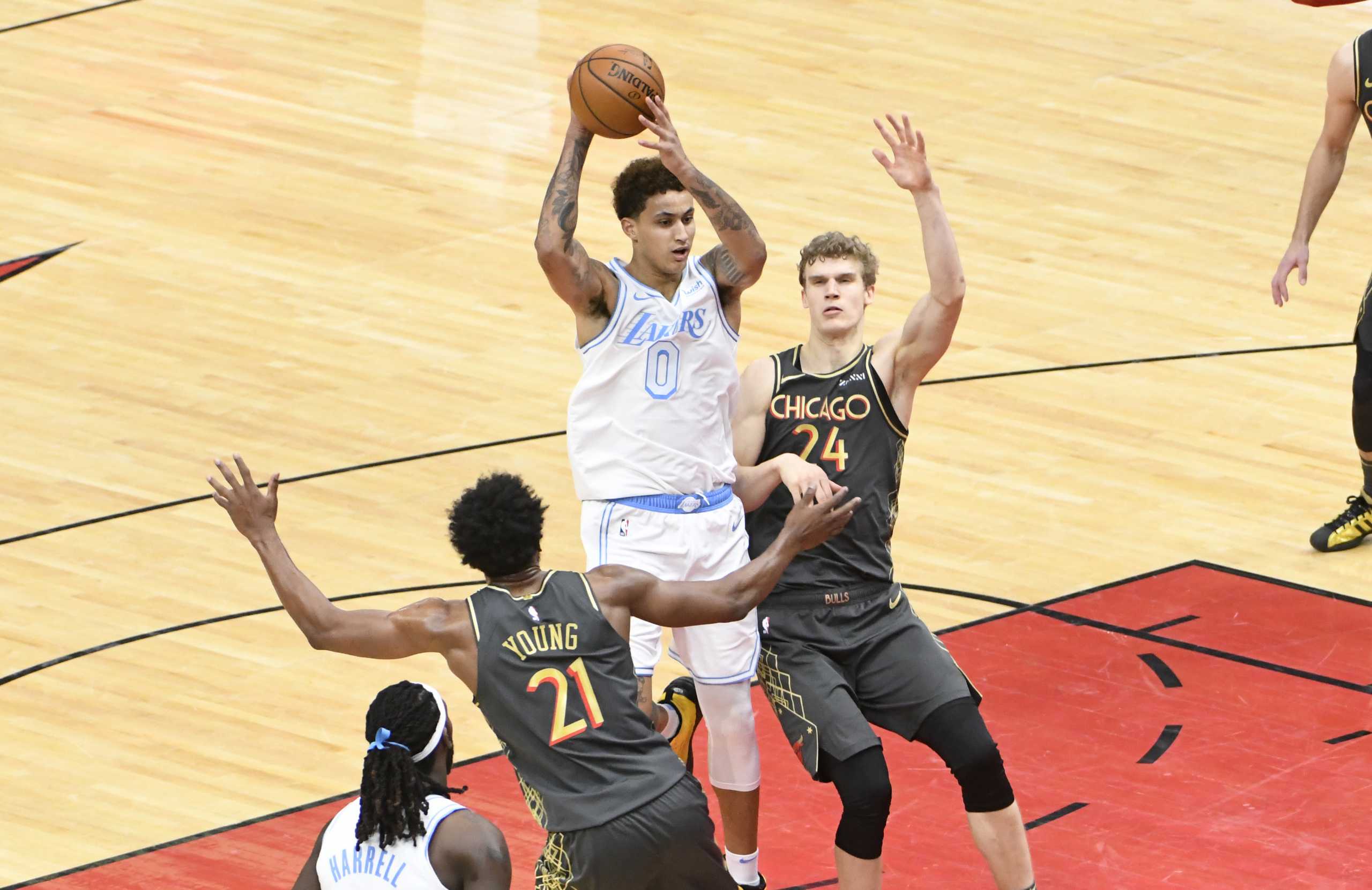 Jan 23, 2021; Chicago, Illinois, USA; Los Angeles Lakers forward Kyle Kuzma (0) is defended by Chicago Bulls forward Lauri Markkanen (24) and forward Thaddeus Young (21) during the second half at United Center. Mandatory Credit: David Banks-USA TODAY Sports