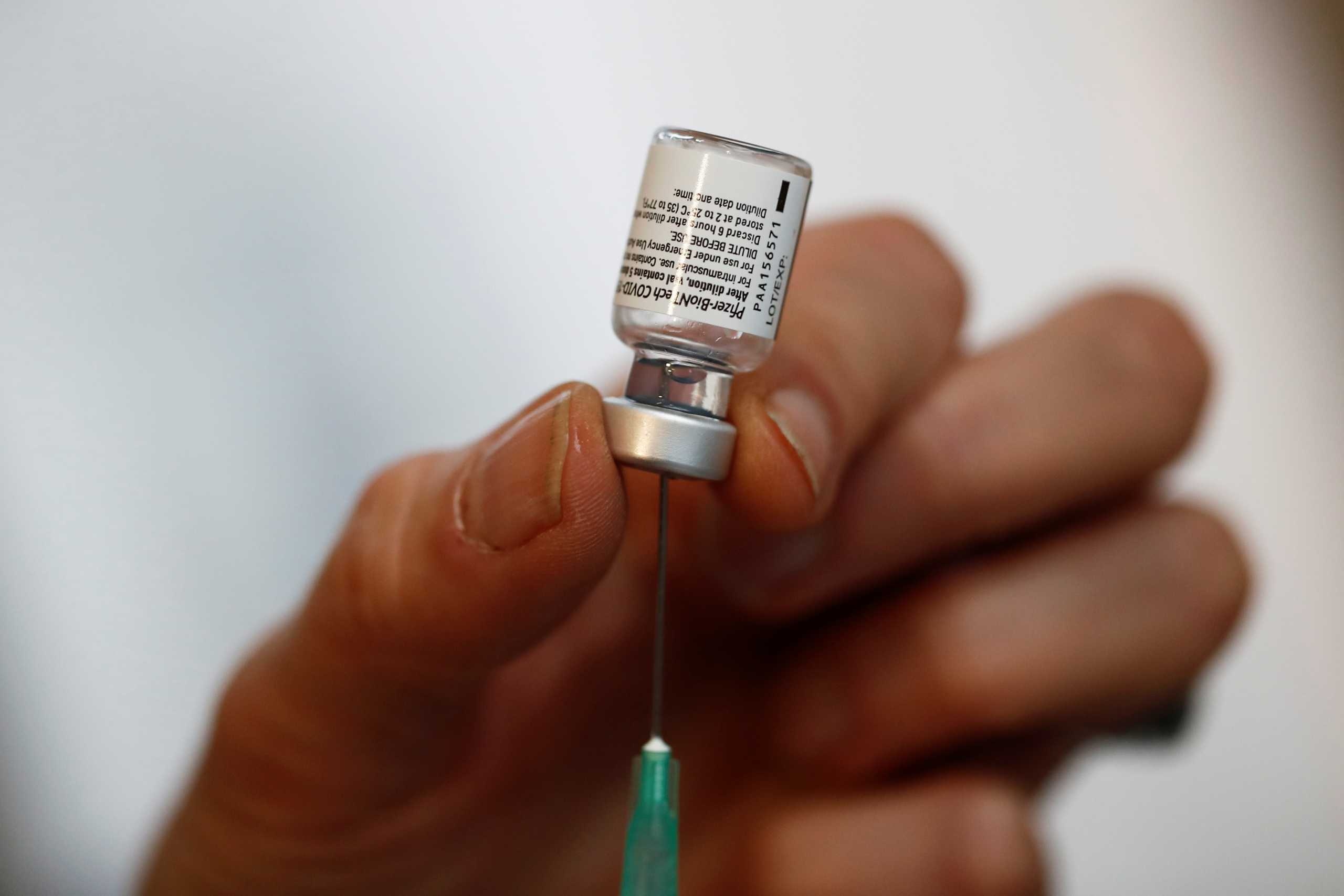 A health worker prepares a syringe with the Pfizer-BioNTech coronavirus disease (COVID-19) vaccine at a vaccination center in the city hall of Paris Centre, France, January 18, 2021. REUTERS