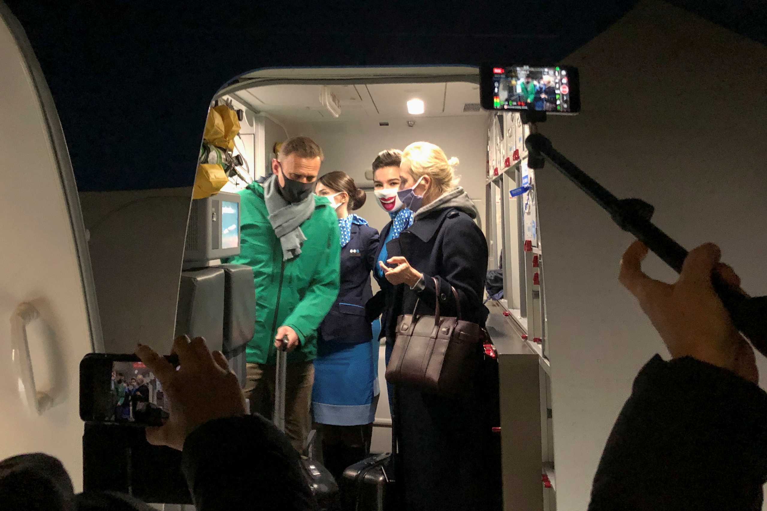 Russian opposition leader Alexei Navalny and his wife Yulia Navalnaya walk out of a plane after arriving at Sheremetyevo airport in Moscow, Russia January 17, 2021. REUTERS