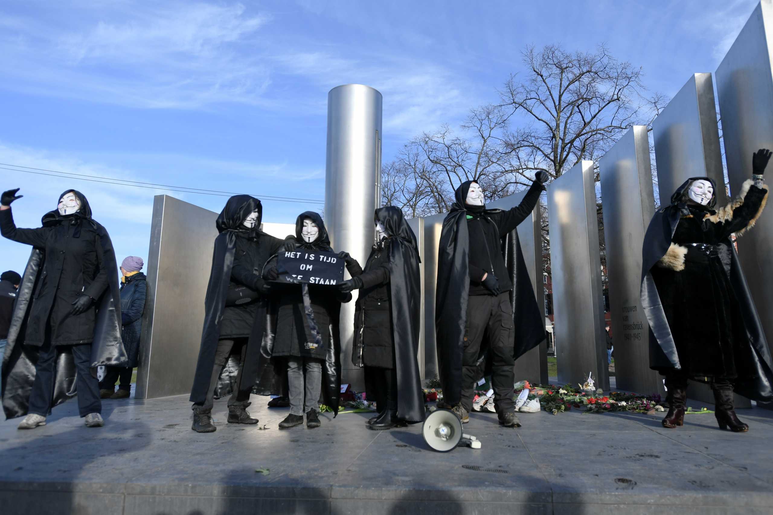 People wearing Guy Fawkes masks attend a protest against restrictions put in place to curb the spread of the coronavirus disease (COVID-19), in Amsterdam, Netherlands January 31, 2021. REUTERS