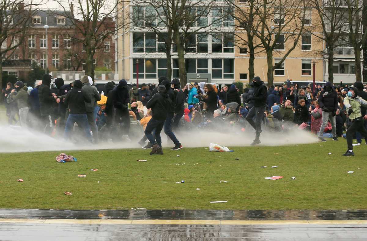 Police uses a water canon during a protest against restrictions put in place to curb the spread of the coronavirus disease (COVID-19), in Amsterdam, Netherlands January 24, 2021. REUTERS