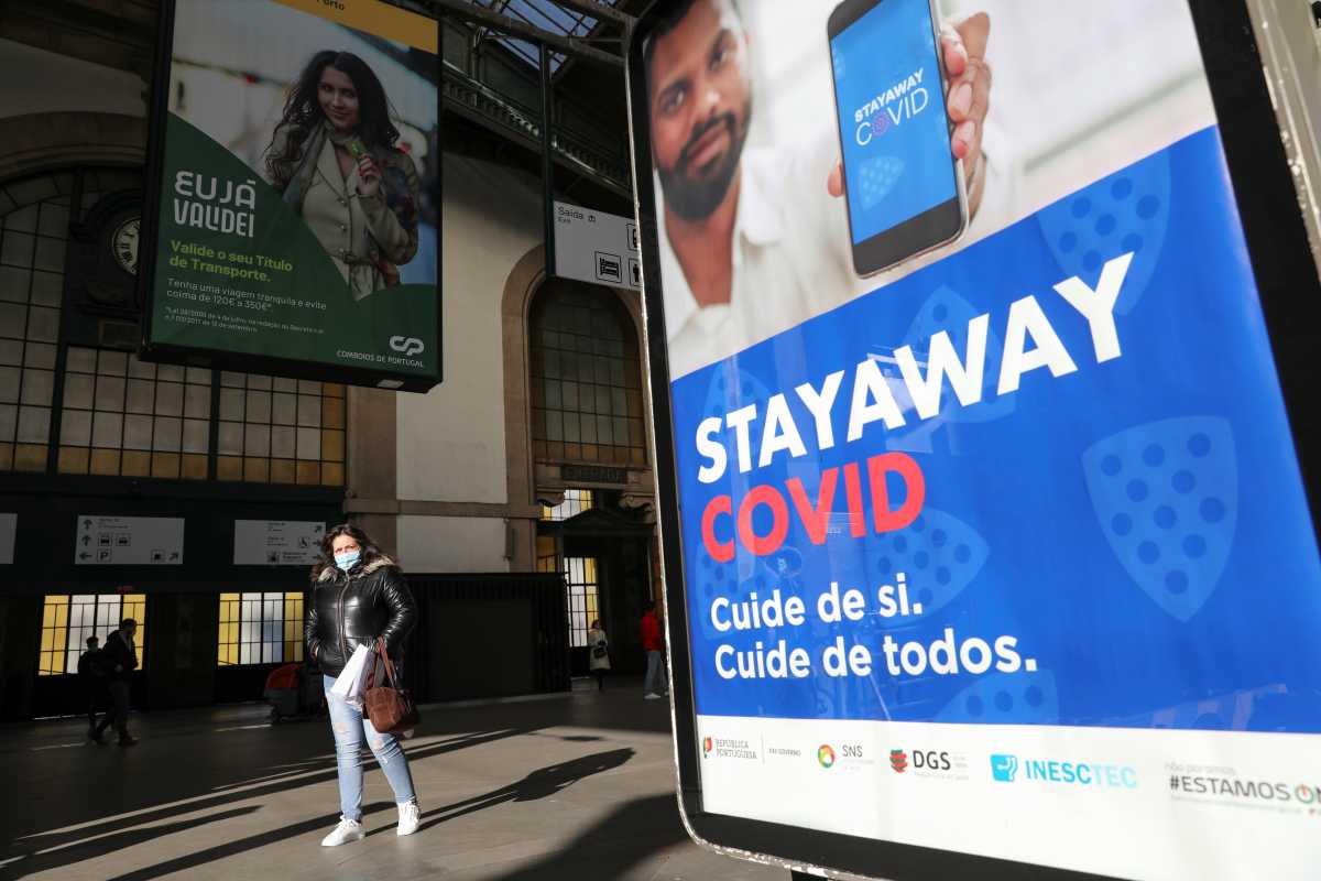 A woman walk past a billboard during a lockdown following a soaring of coronavirus disease (COVID-19) in Porto, Portugal January 18, 2021. REUTERS