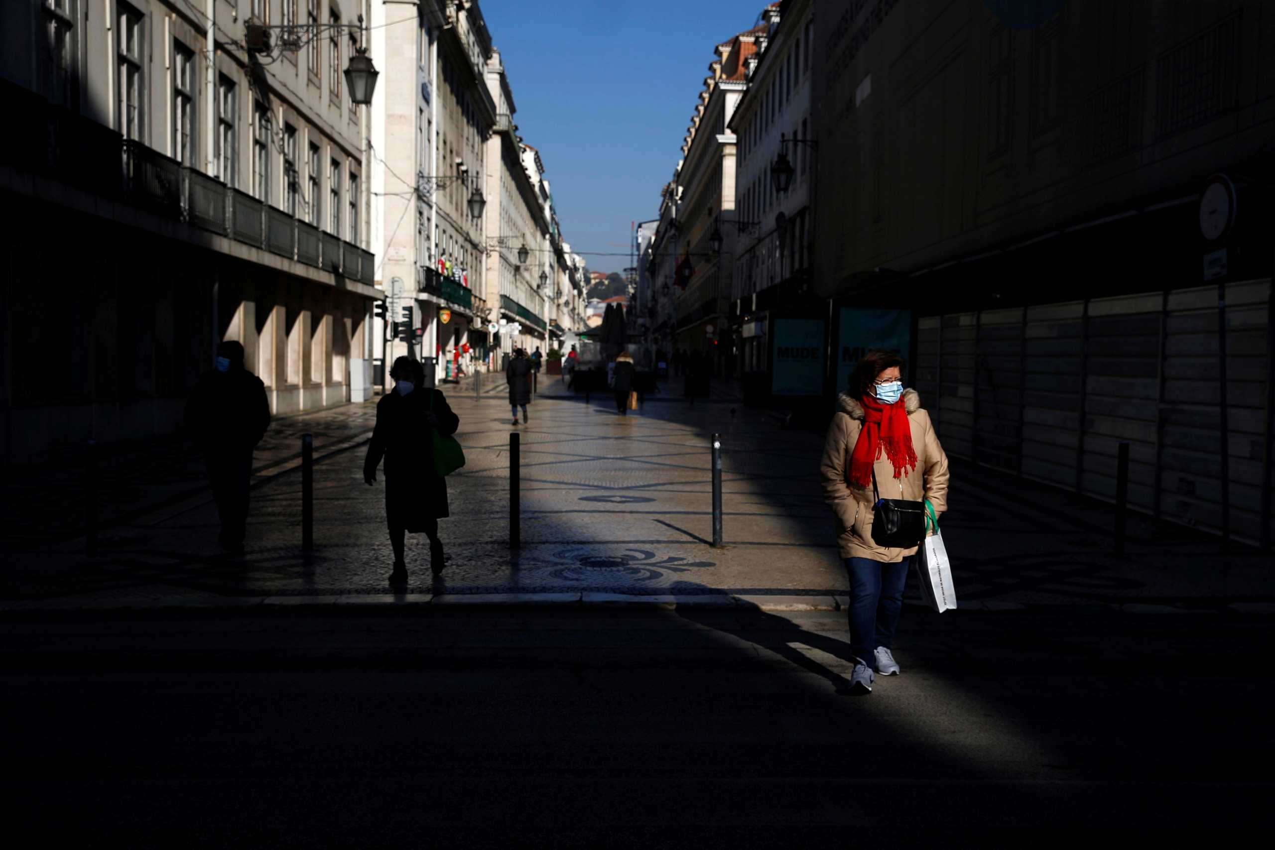 People wearing protective masks walk by in Lisbon before the prime minister announces the new lockdown due to the coronavirus disease (COVID-19) pandemic in Portugal, January 13, 2021. REUTERS