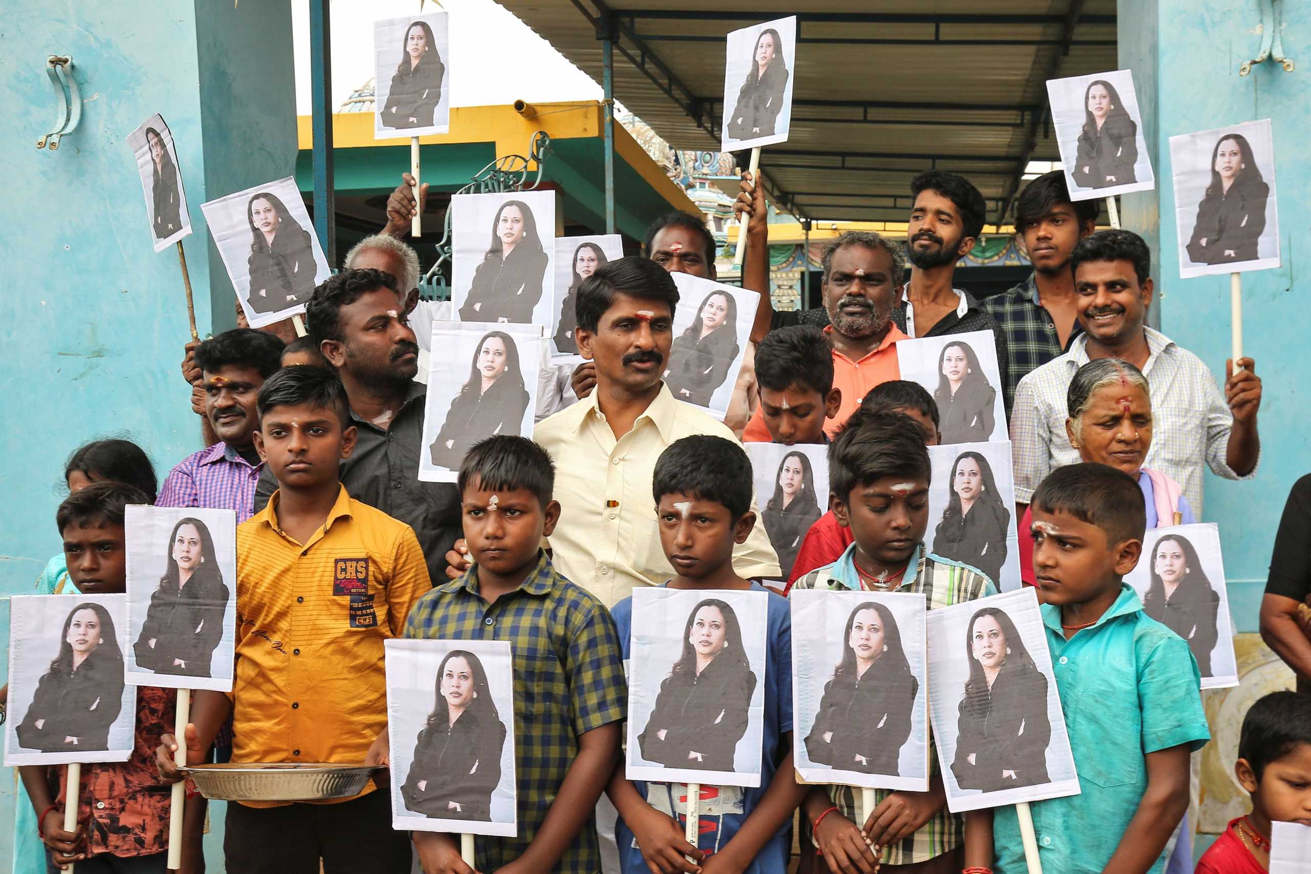 People holding placards with the photo of Vice President-elect Kamala Harris celebrate on the day of her inauguration in the village of Thulasendrapuram, where Harris' maternal grandfather was born and grew up, in the southern Indian state of Tamil Nadu, India, January 20, 2021. REUTERS