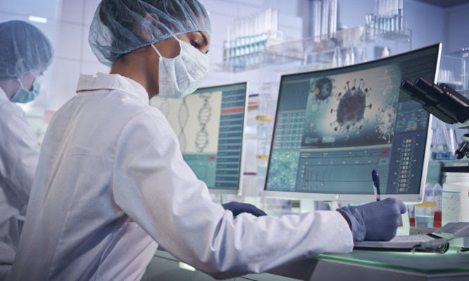 Young team during coronavirus lab tests. Wearing protective masks and caps