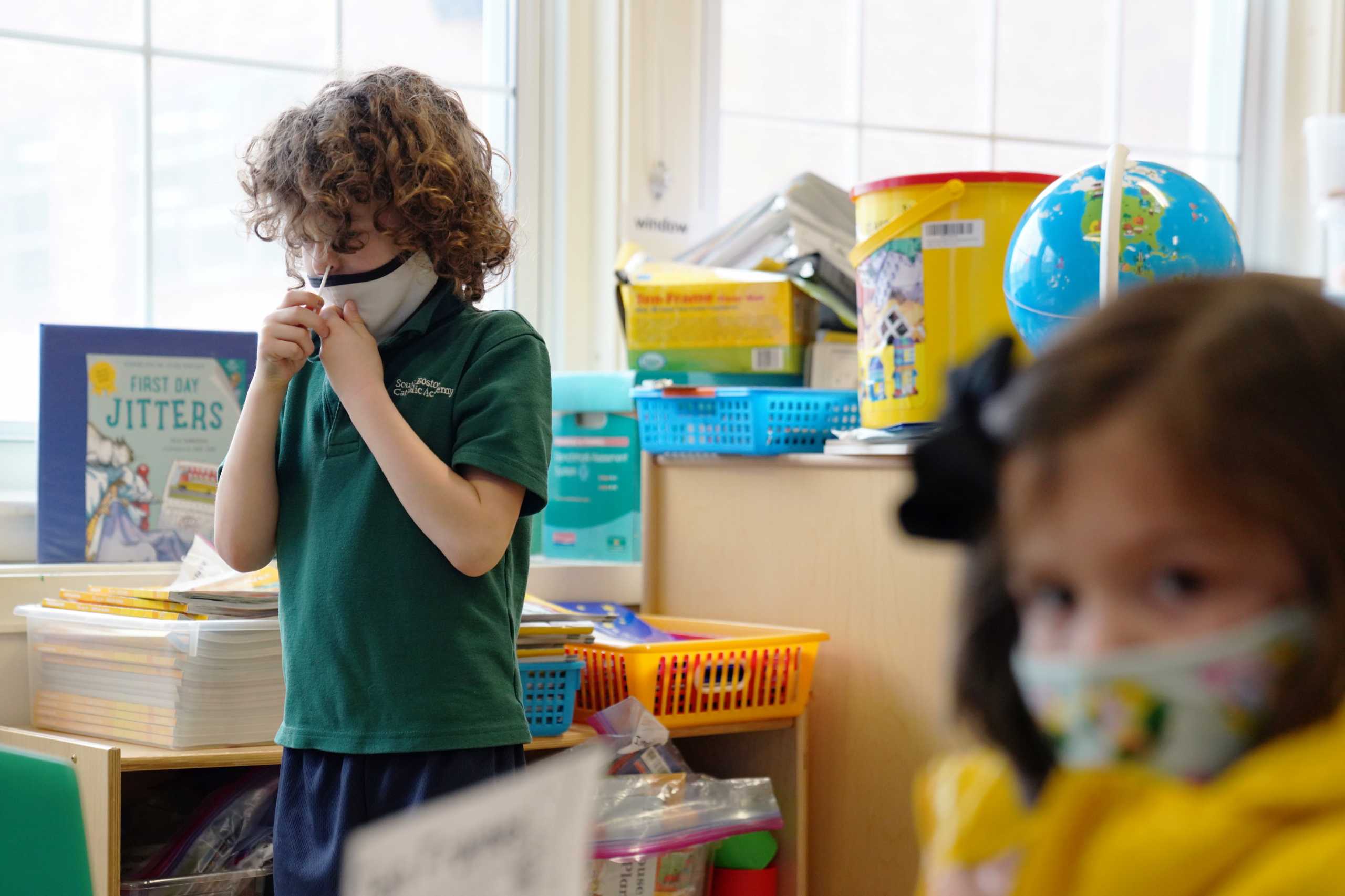 Schoolchildren swab and test themselves for COVID-19 to prevent the spread of the coronavirus disease (COVID-19) in the classroom at South Boston Catholic Academy in Boston, Massachusetts, U.S., January 28, 2021.  REUTERS