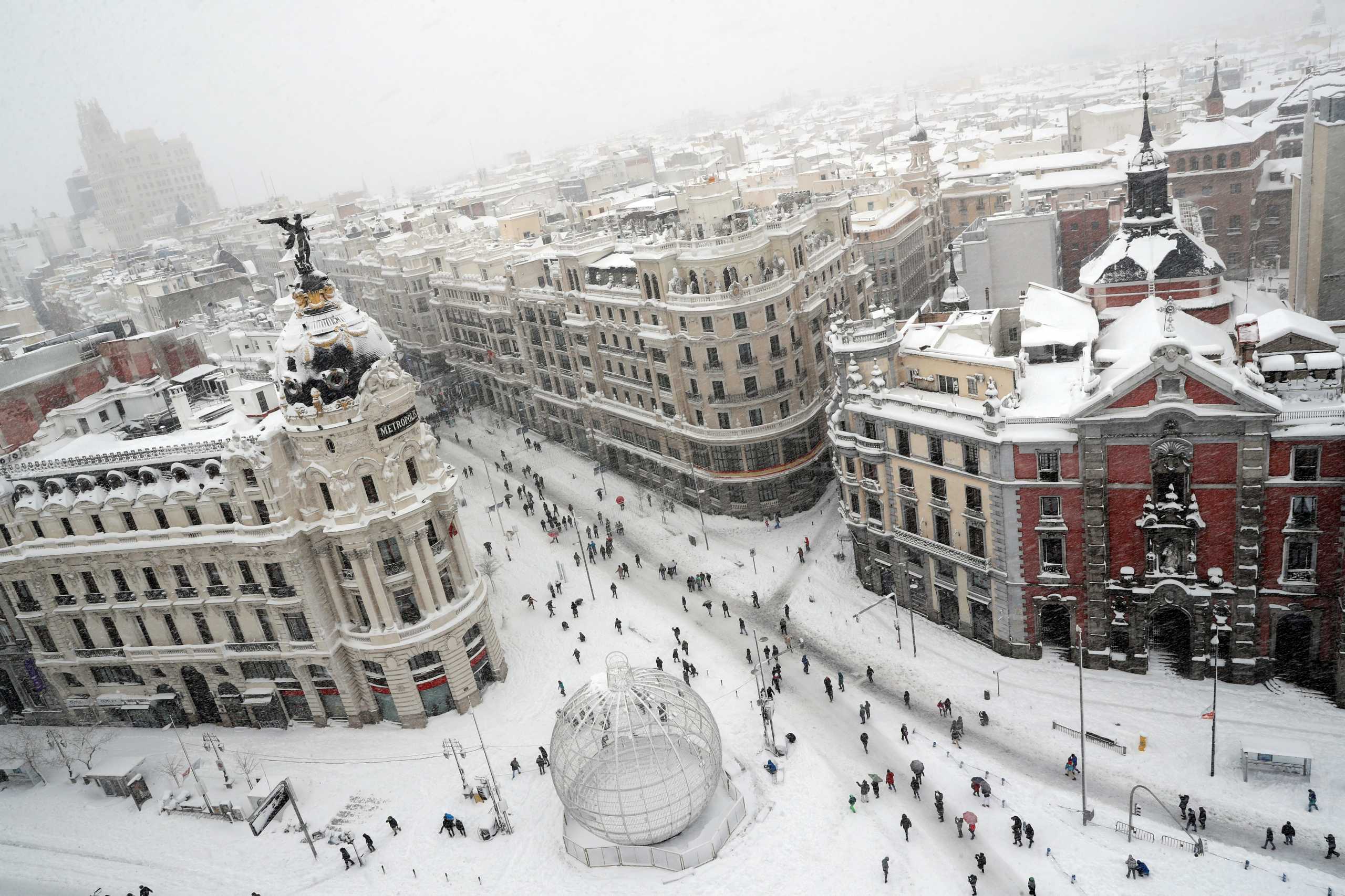 People are seen from the rooftop of the Circulo de Bellas Artes cultural center, as they walk at the start of Gran Via street during a heavy snowfall in Madrid, Spain January 9, 2021. REUTERS