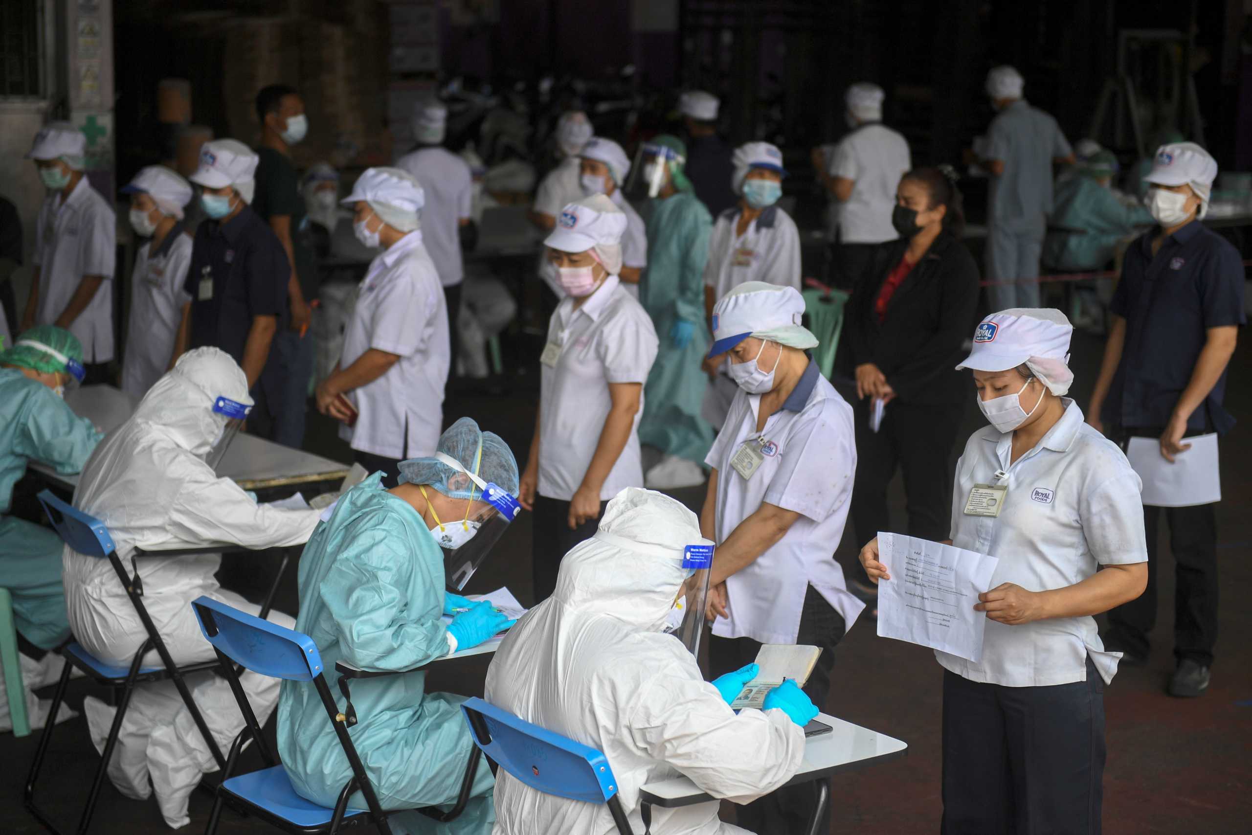 Migrant workers queue to be tested for COVID-19 during proactive testing at their work place, amid the spread of the coronavirus disease (COVID-19) outbreak in Samut Sakhon province in Thailand, January 27, 2021. REUTERS