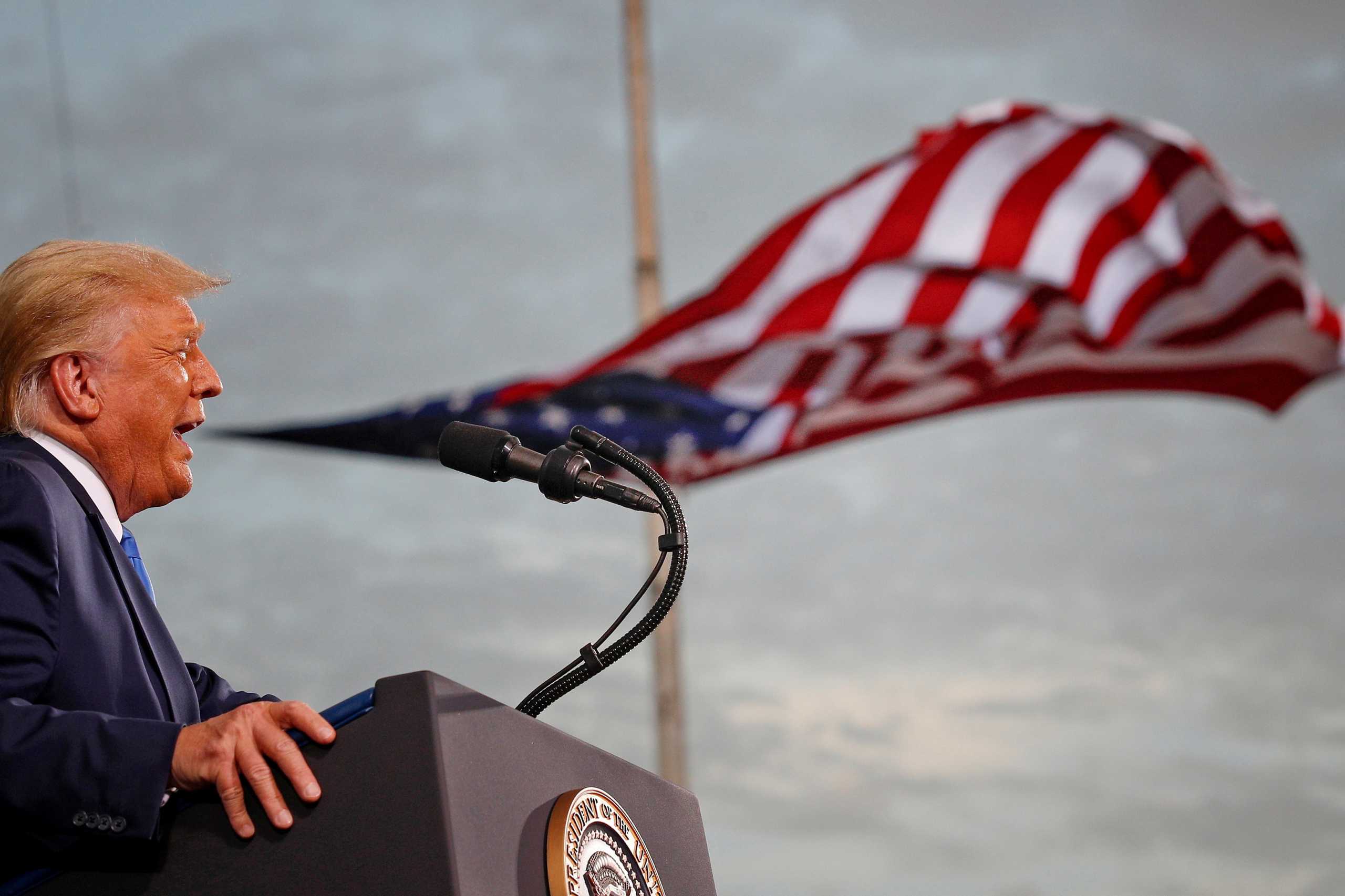 FILE PHOTO: FILE PHOTO: President Donald Trump speaks, with a flag behind him, during a campaign rally at Cecil Airport in Jacksonville, Florida, September 24, 2020. REUTERS