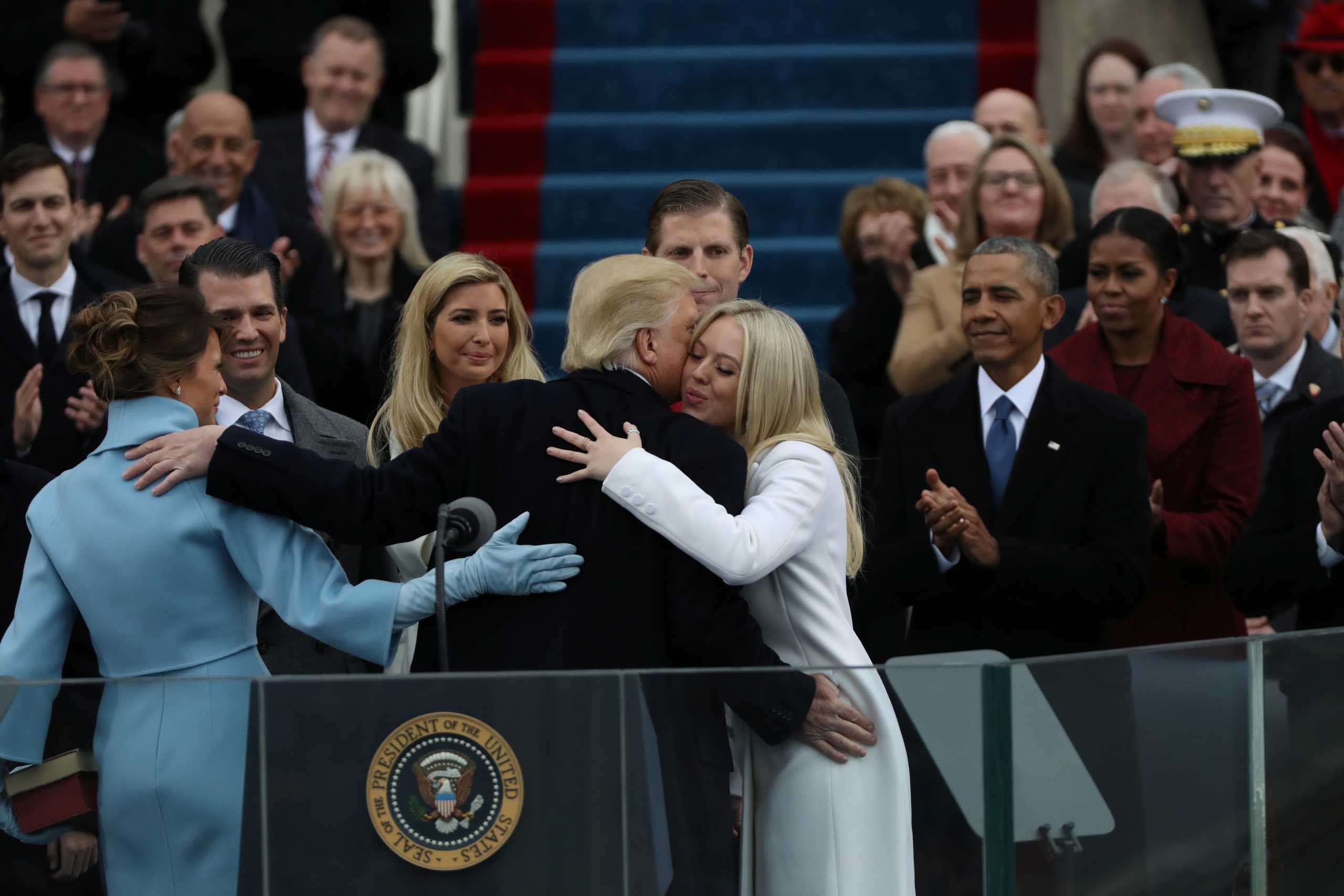 Outgoing U.S. President Barack Obama and outgoing first lady Michelle Obama watch as U.S. President Donald Trump embraces members of his family, wife Melania, and children Barron, Donald, Ivanka and Tiffany, after Donald Trump was sworn in during inauguration ceremonies at the Capitol in Washington, U.S., January 20, 2017. REUTERS