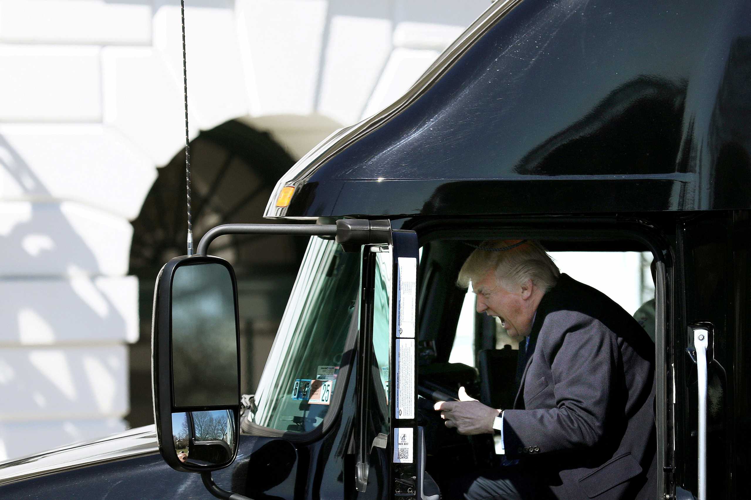 FILE PHOTO: U.S. President Donald Trump reacts as he sits on a truck while he welcomes truckers and CEOs to attend a meeting regarding healthcare at the White House in Washington, U.S., March 23, 2017.   REUTERS
