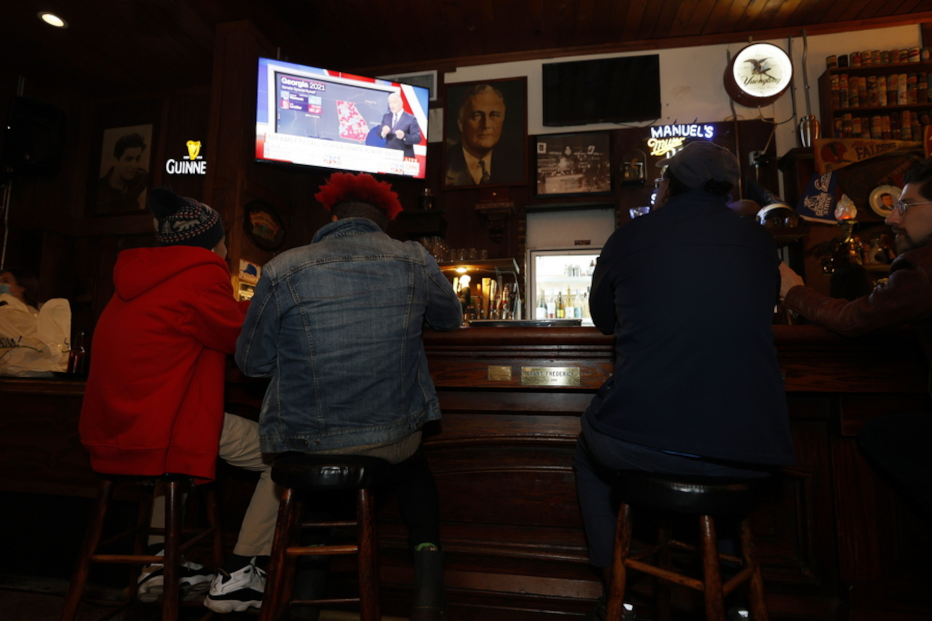epa08921282 People watch election results come in after the polls closed in the parking lot of Manuel's Tavern in Atlanta, Georgia, USA, 05 January 2021. Republican Senator David Perdue is running against Democrat Jon Ossoff and Republican Senator Kelly Loeffler is running against Democrat Reverend Raphael Warnock in the 05 January 2021 runoff election.  EPA