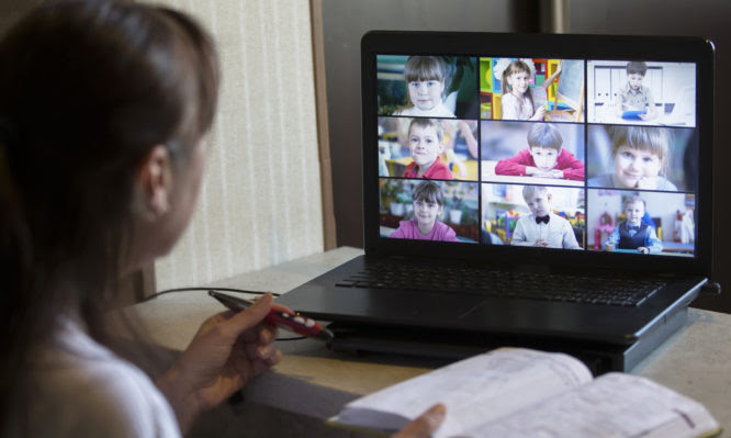 Back view of teacher talking with children in a video conference. Teacher and students using laptop for online learning in video call. A group of schoolchildren studying from home.